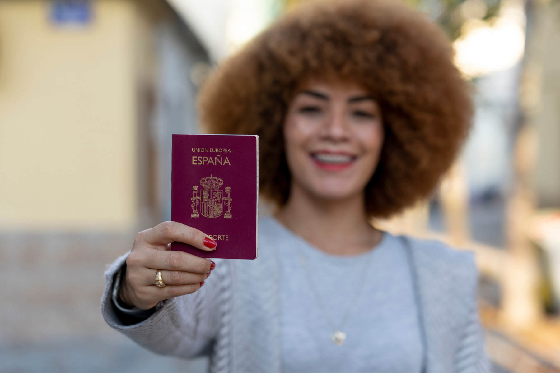 a young woman holding up her Spanish passport