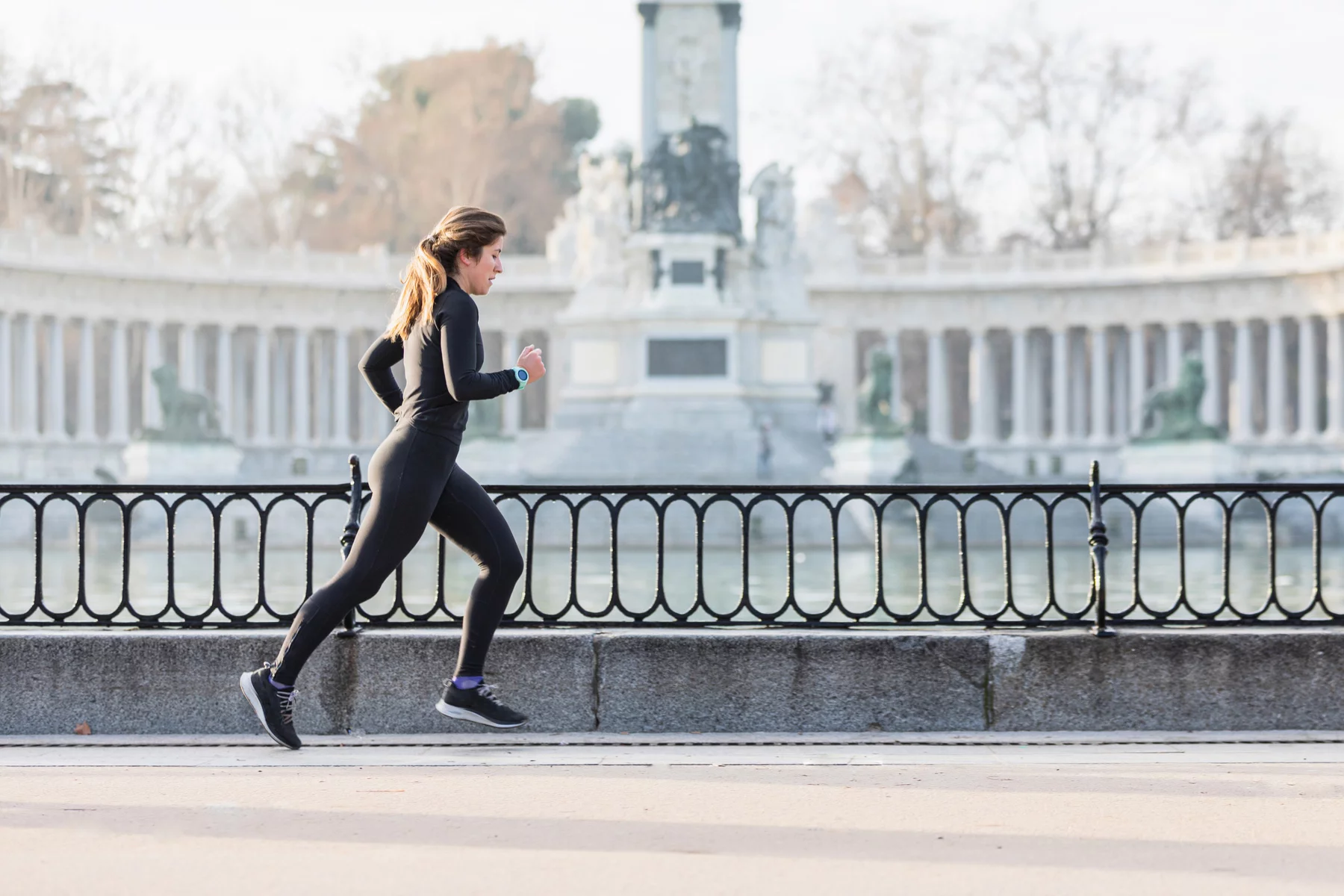 Woman running through a park in Madrid