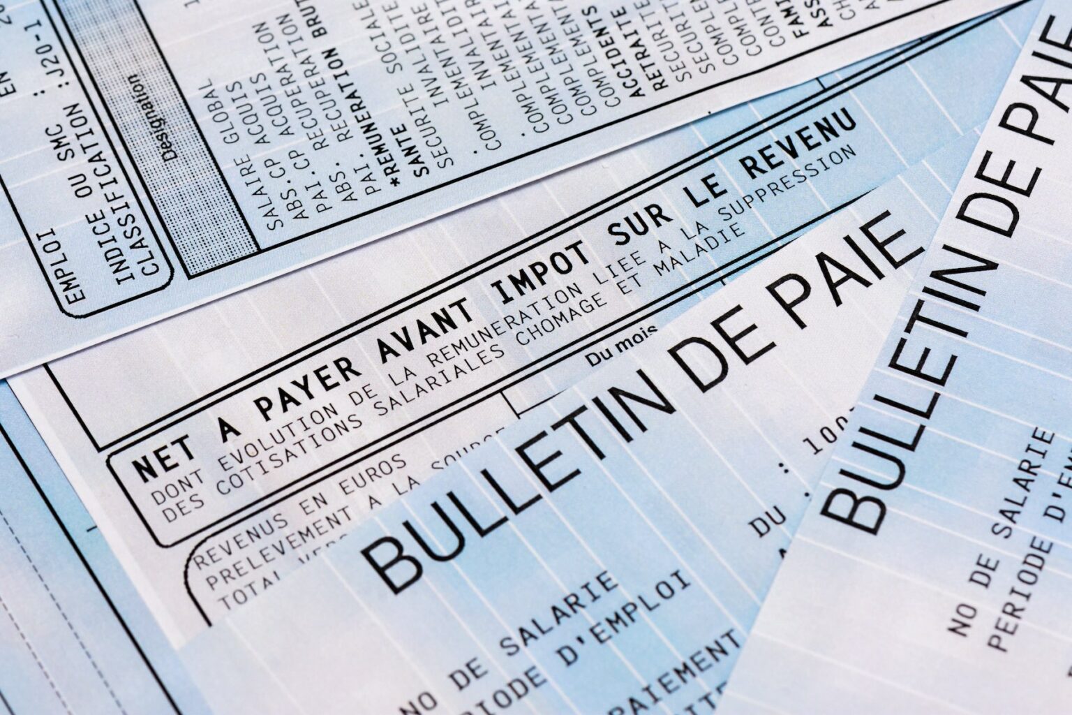 A close-up of pay slips in French, showing income tax amounts