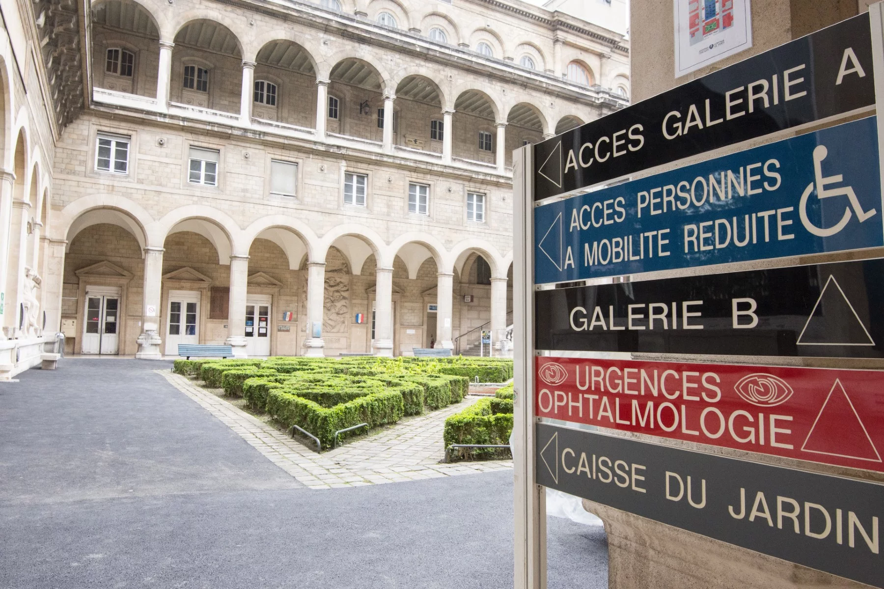 interior courtyard of a hospital in France with signage