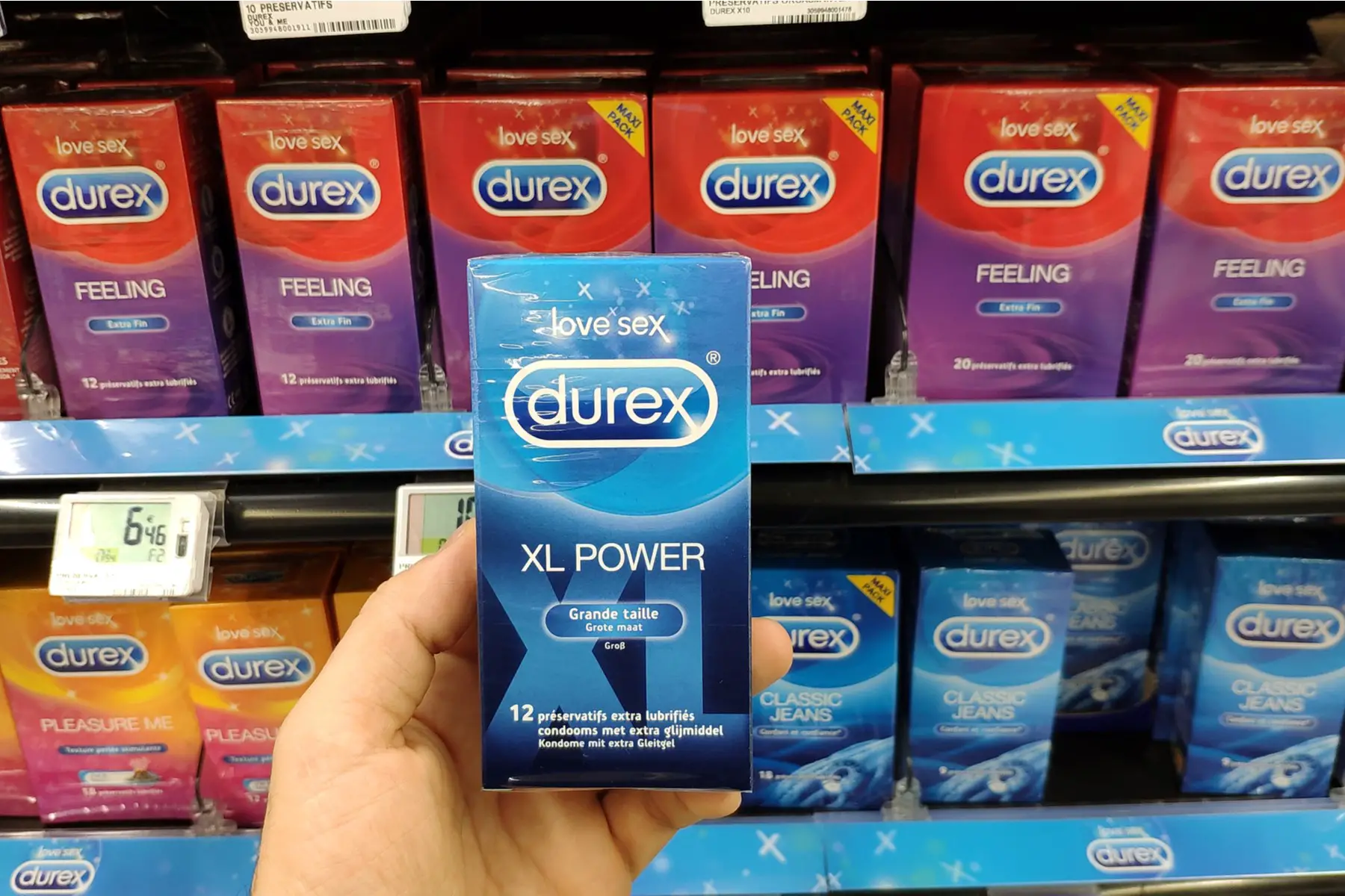 someone holding a box of condoms in a supermarket