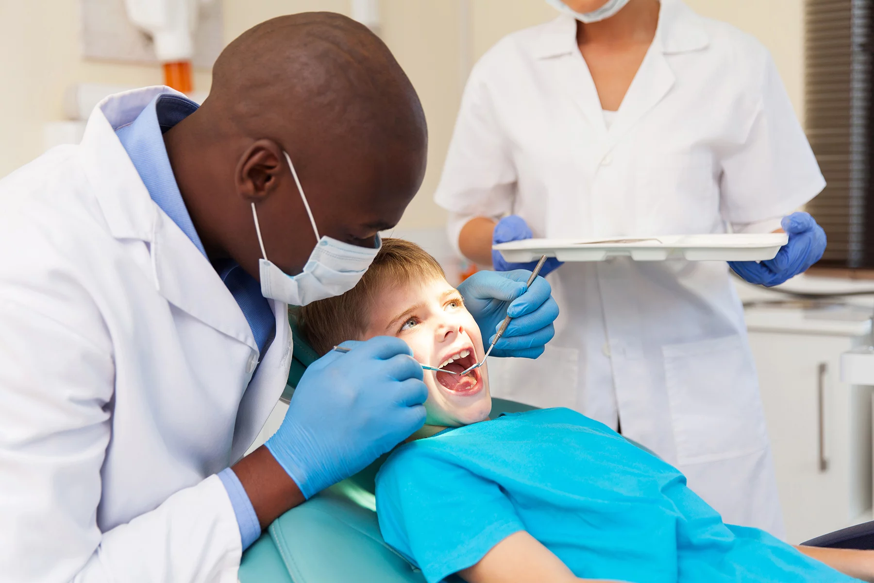 Dentist checking a child's teeth in chair