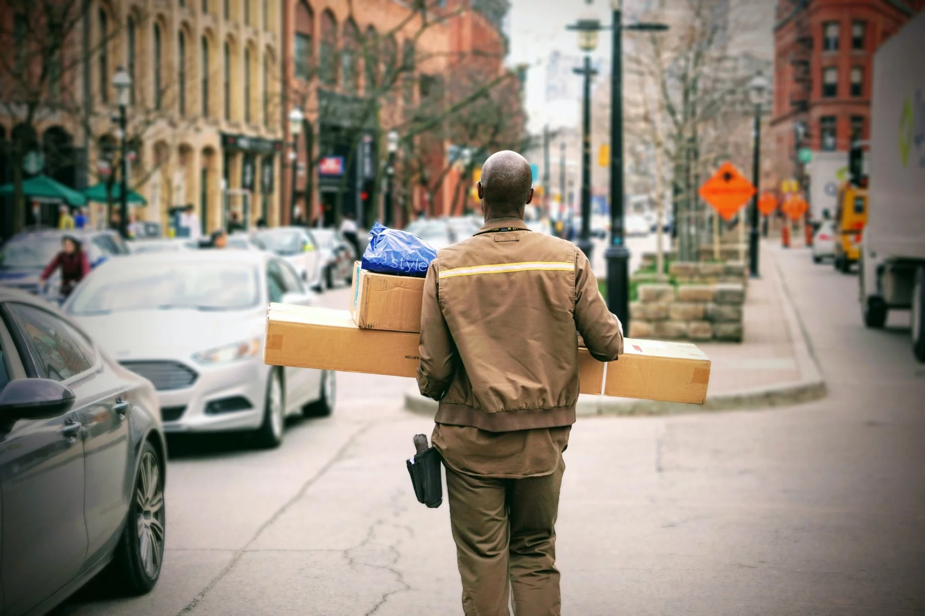 Man in brown jacket delivering large packages