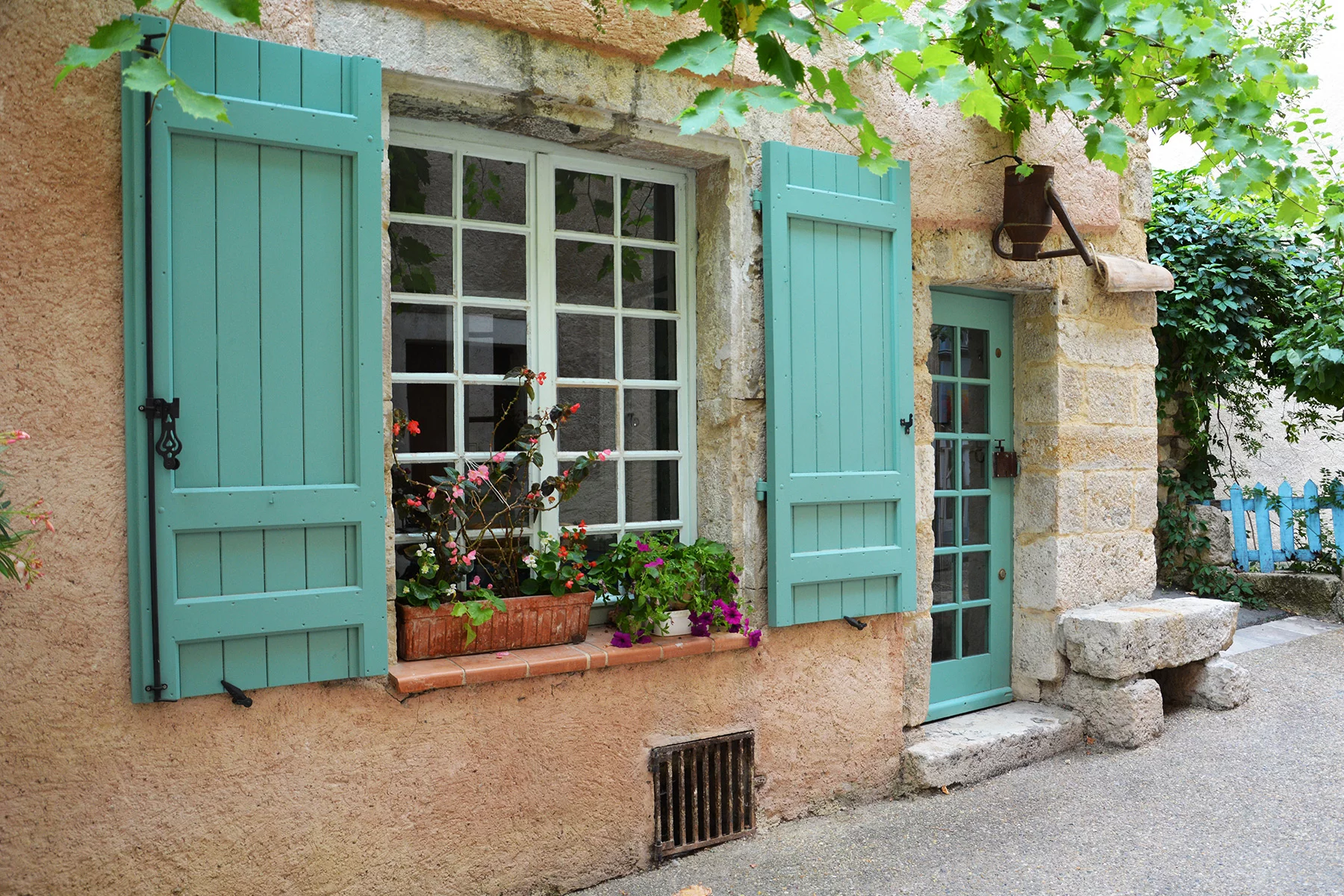 An old house in Provence with mint green shutters on the windows