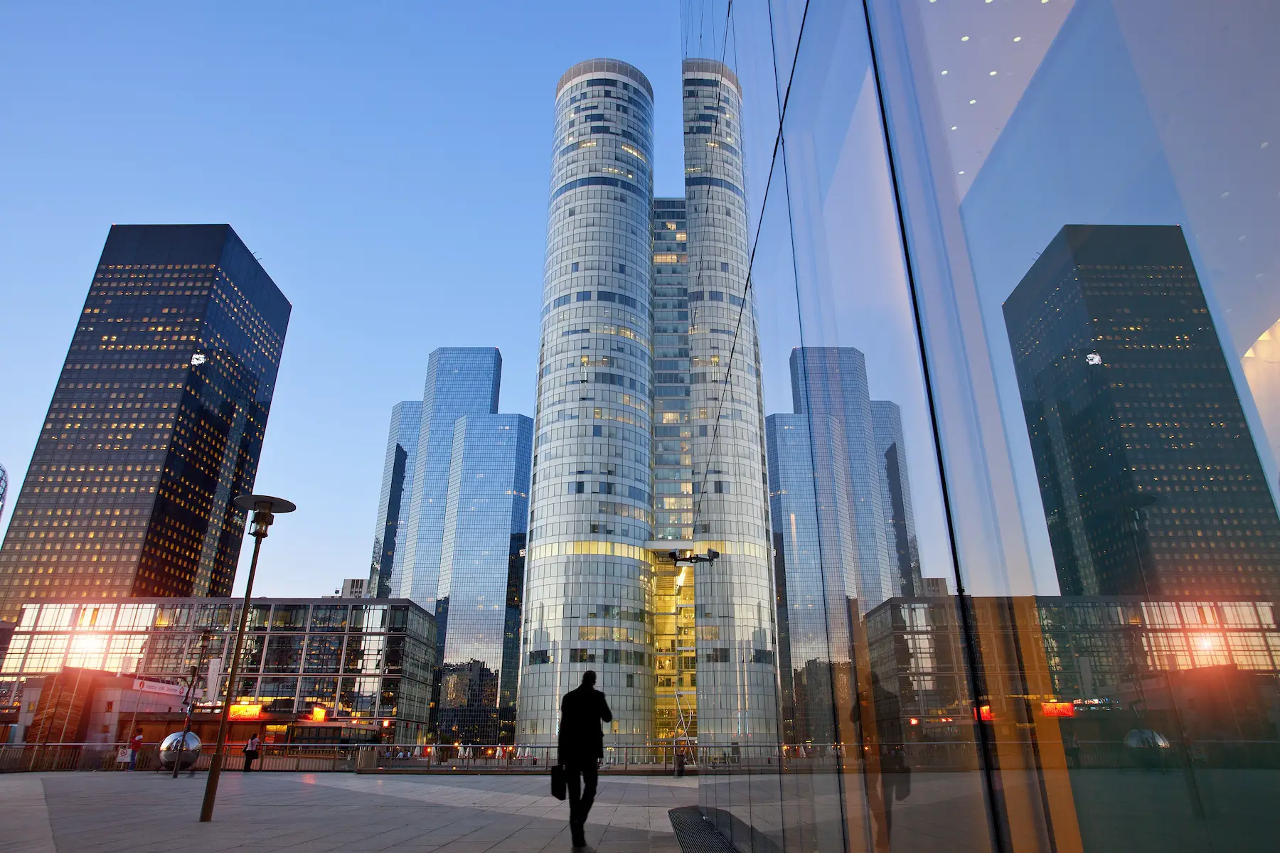 Paris business district, La Défense, is shown at sunrise, with the sun reflecting off the buildings