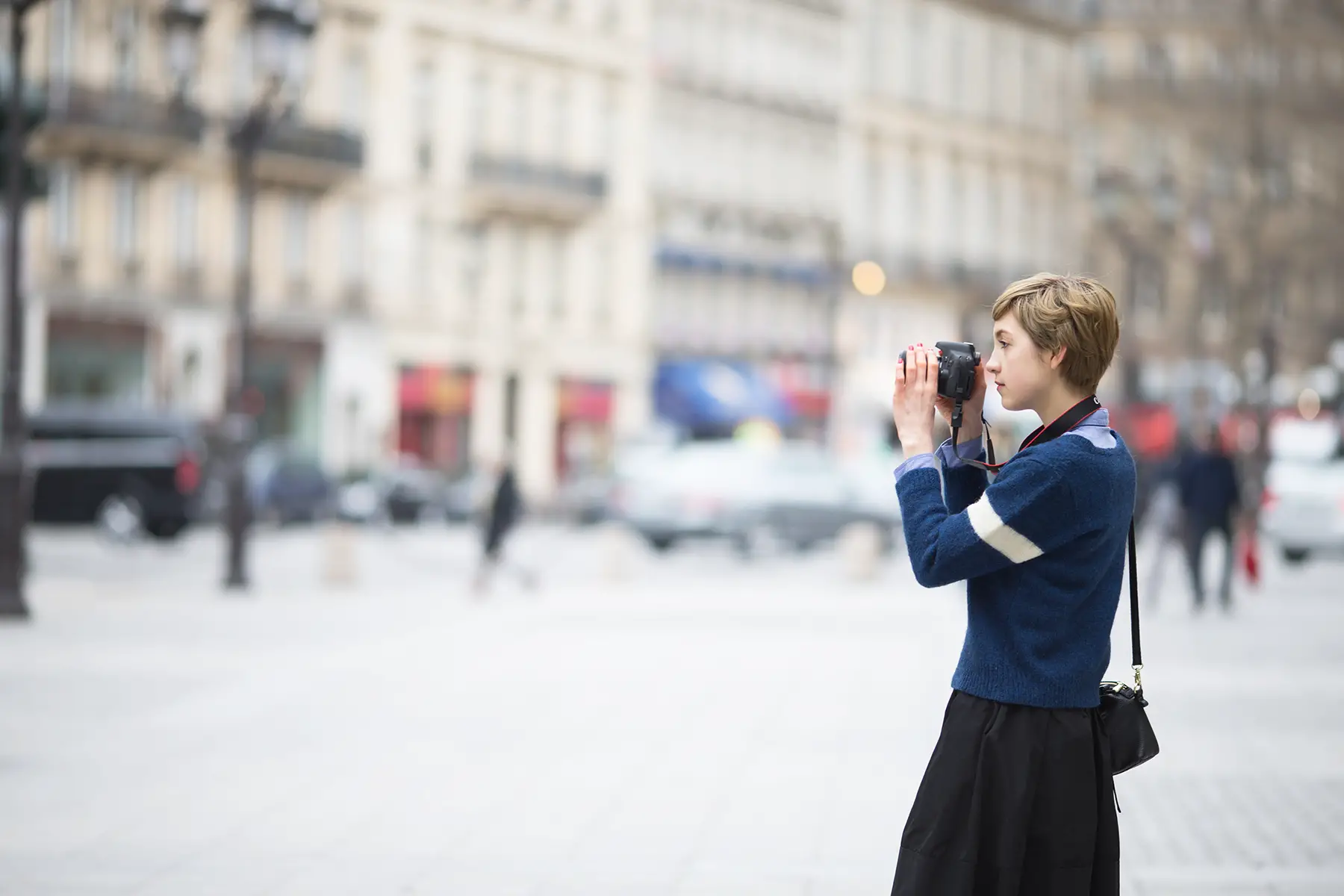 A photographer taking a picture against an out-of-focus background