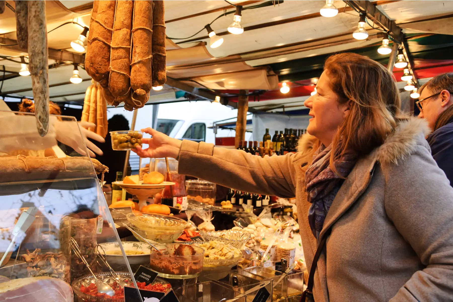 a woman speaking French with a local market vendor