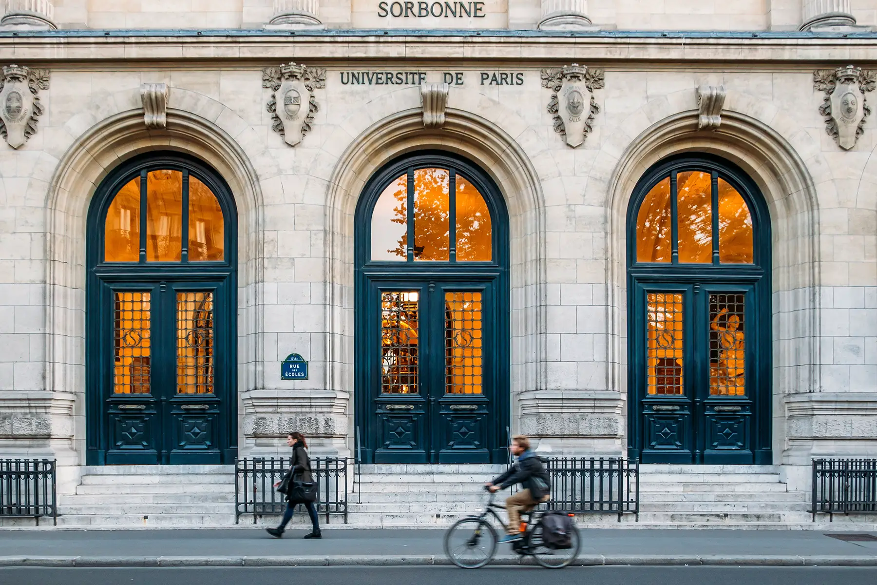 Exterior of Sorbonne University, people walking past and cycling
