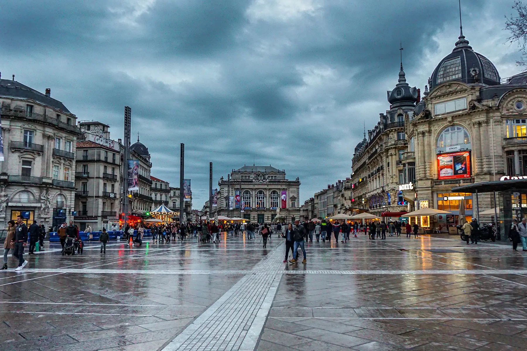 A large square in Montpellier on a rainy day. Fun fair in the background