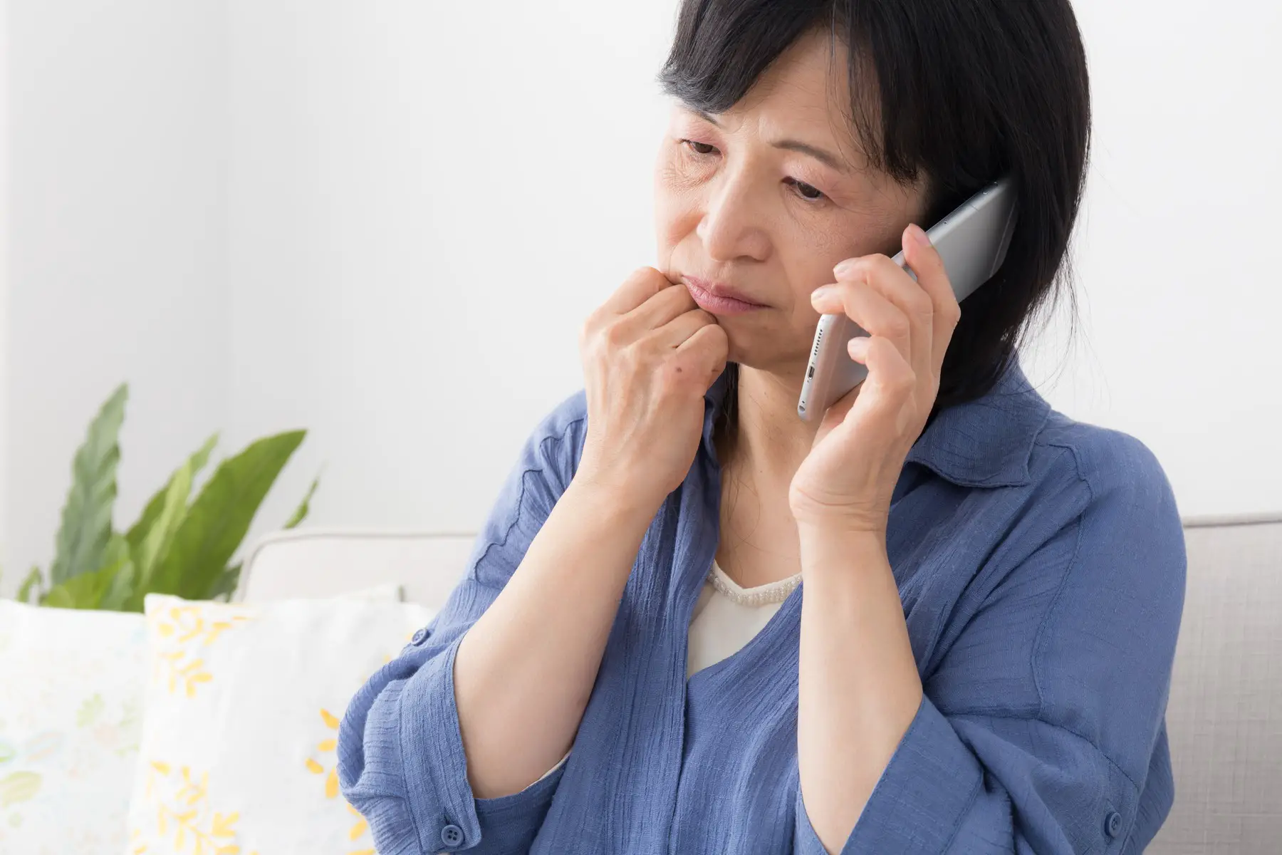 Mature woman calling eating disorder hotline, looks sad