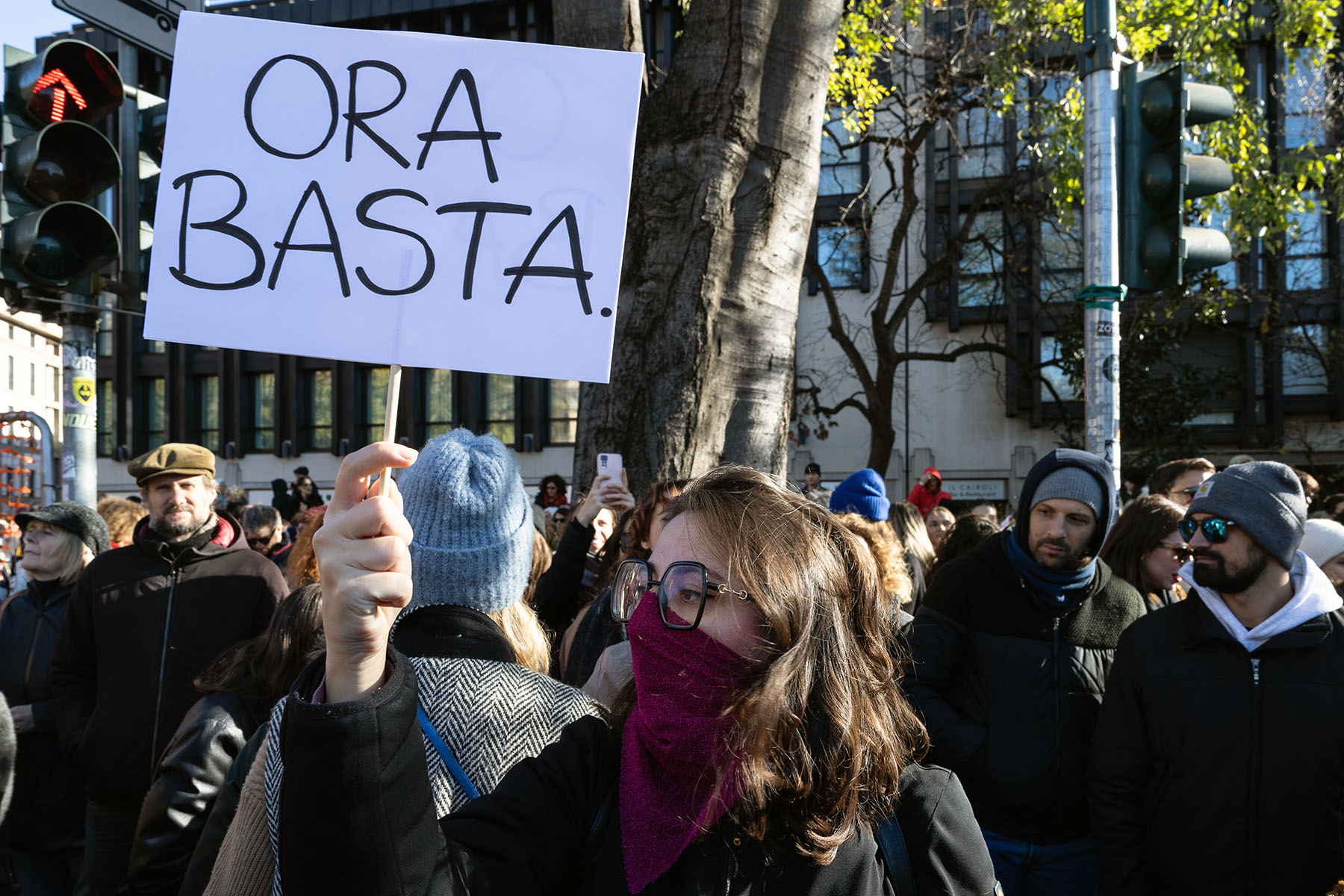 An activist holds a sign that says "No basta" (It's enough) during the 2023 "Il Patriarcato Uccide" (Patriarchy Kills) demonstration in Milan.