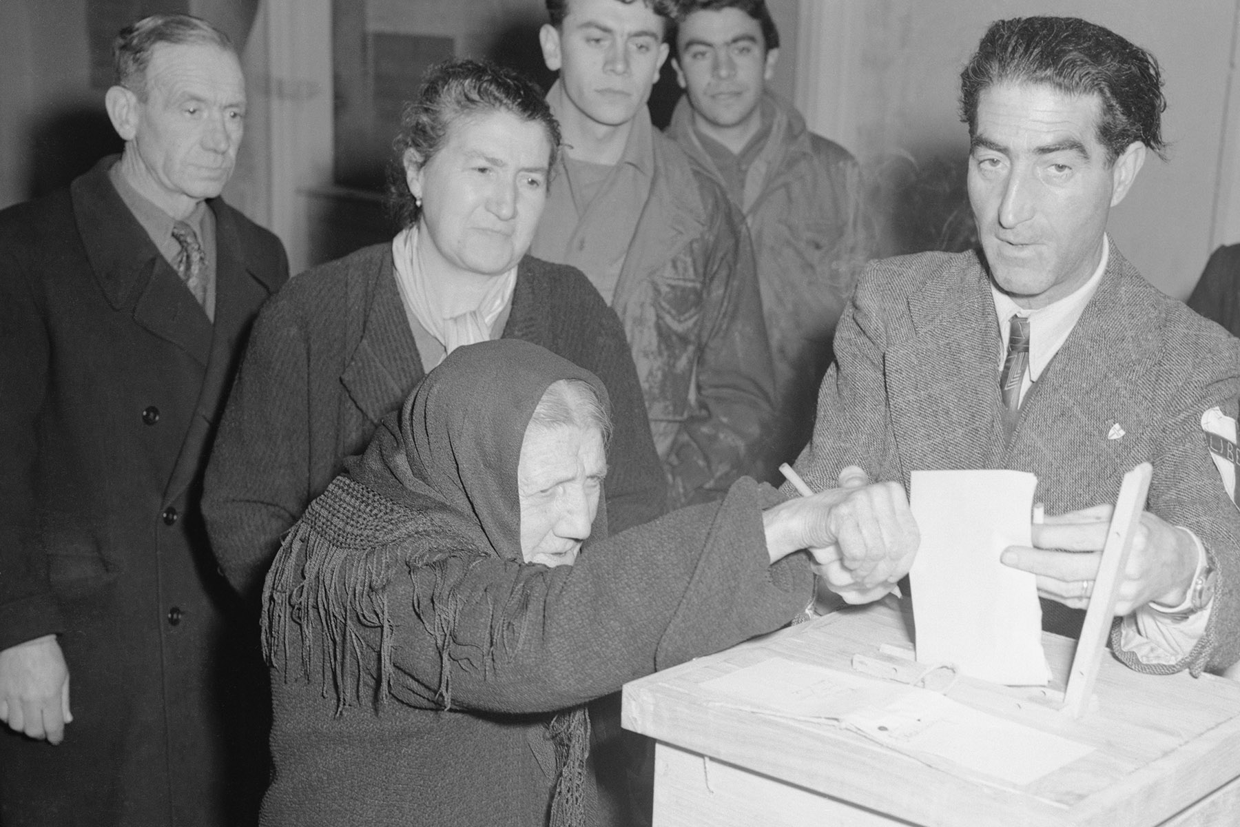 82-year old Maria Castaldo is assisted by clerk, as she casts her vote for the first time in her life, in the referendum to overthrow the Fascist government in Italy.