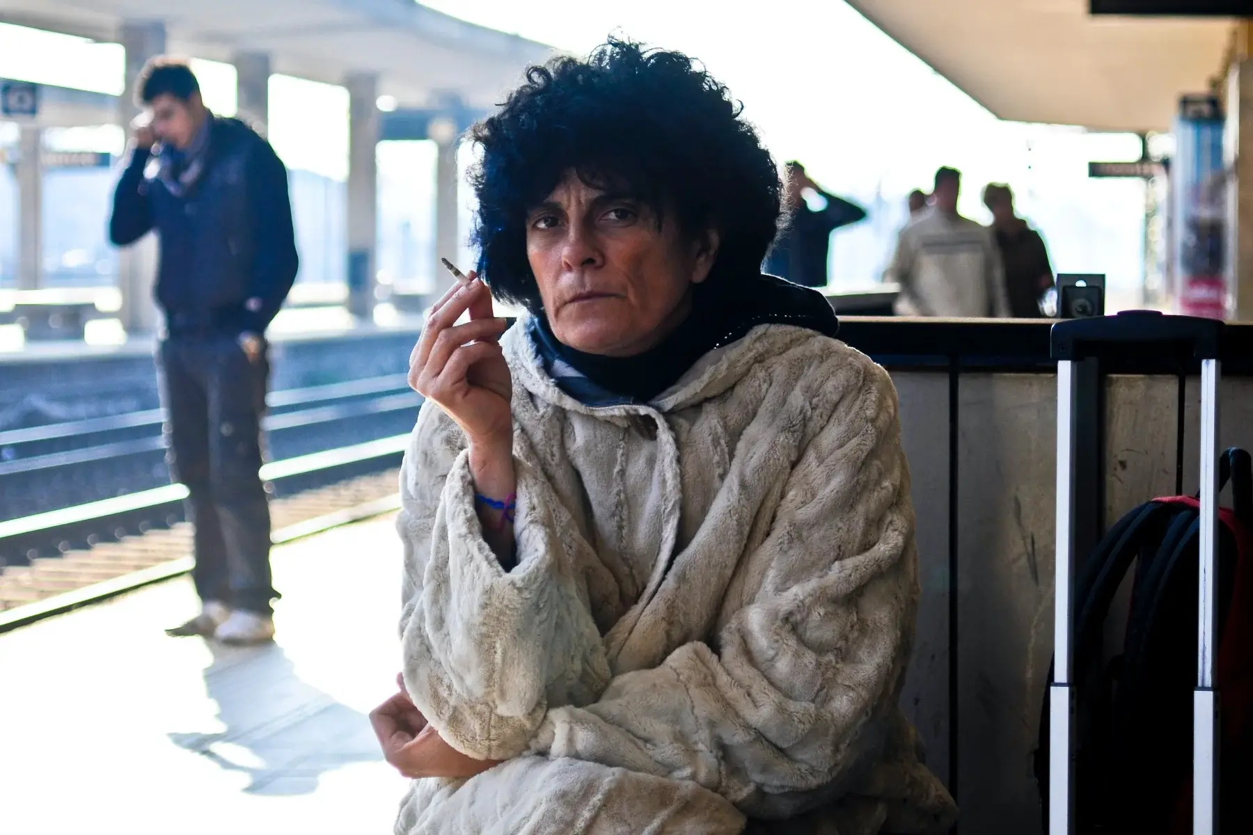 Angry woman smoking a cigarette at an Italian train station