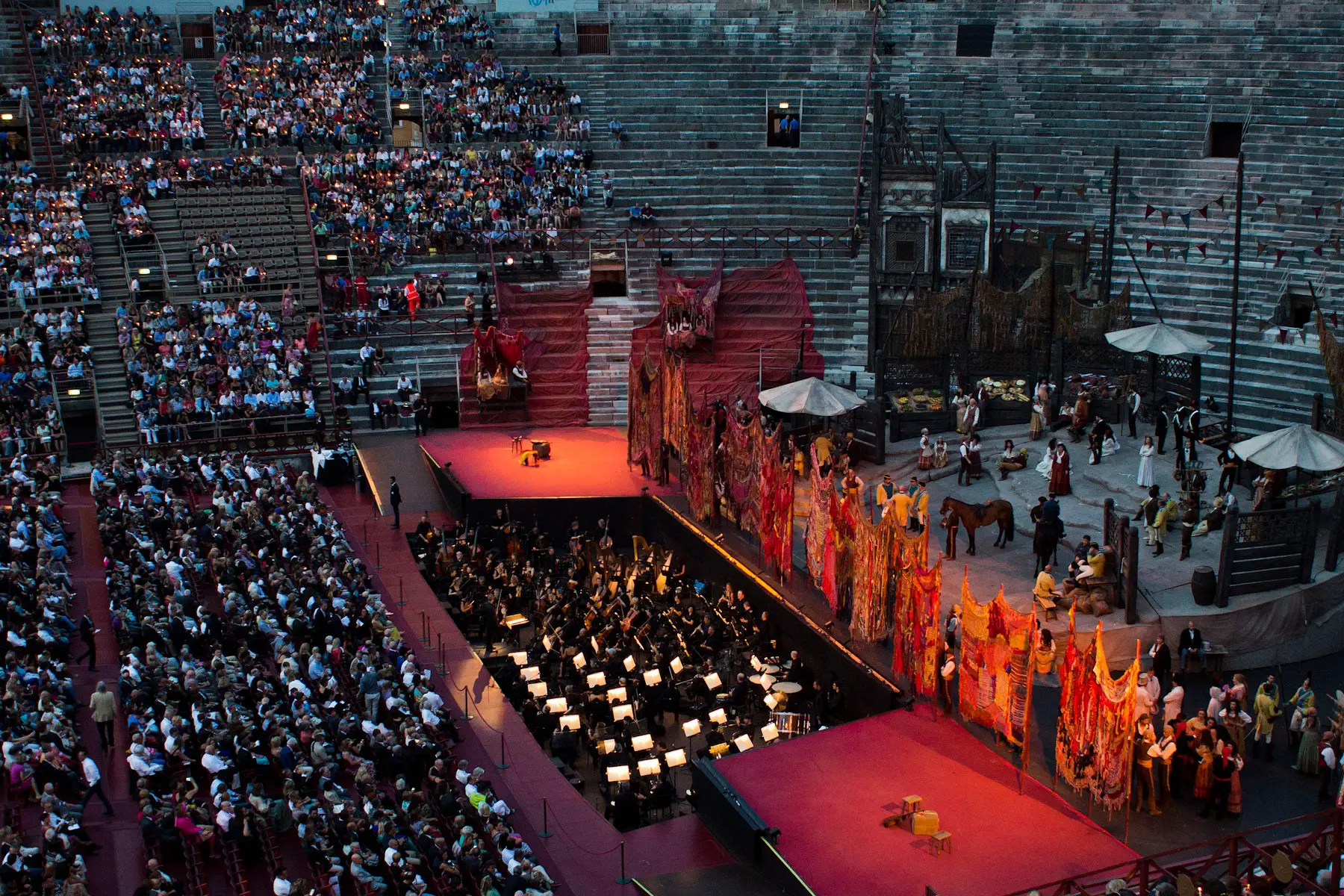Visitors sitting on the stone steps in the Arena of Verona in Italy 
