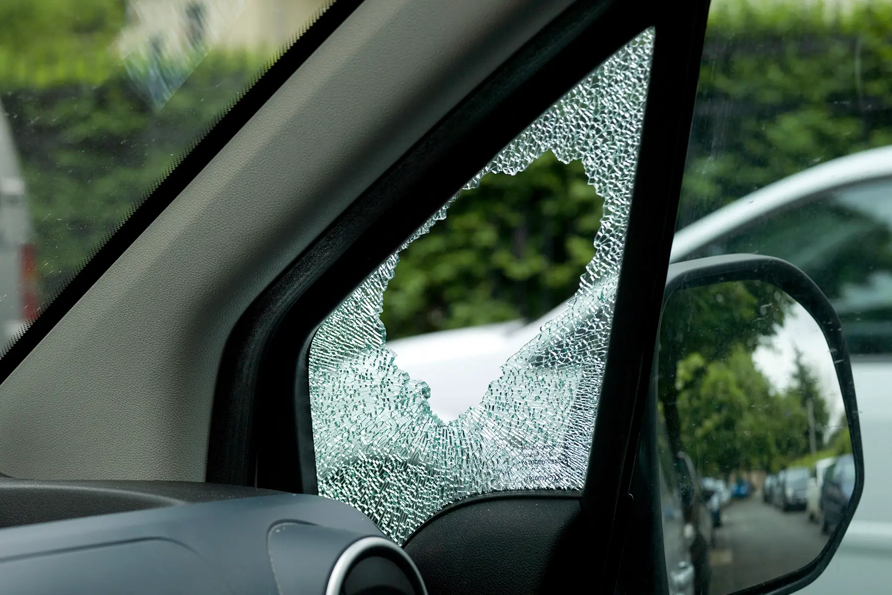 View from inside a car parked on the street with its side window smashed open
