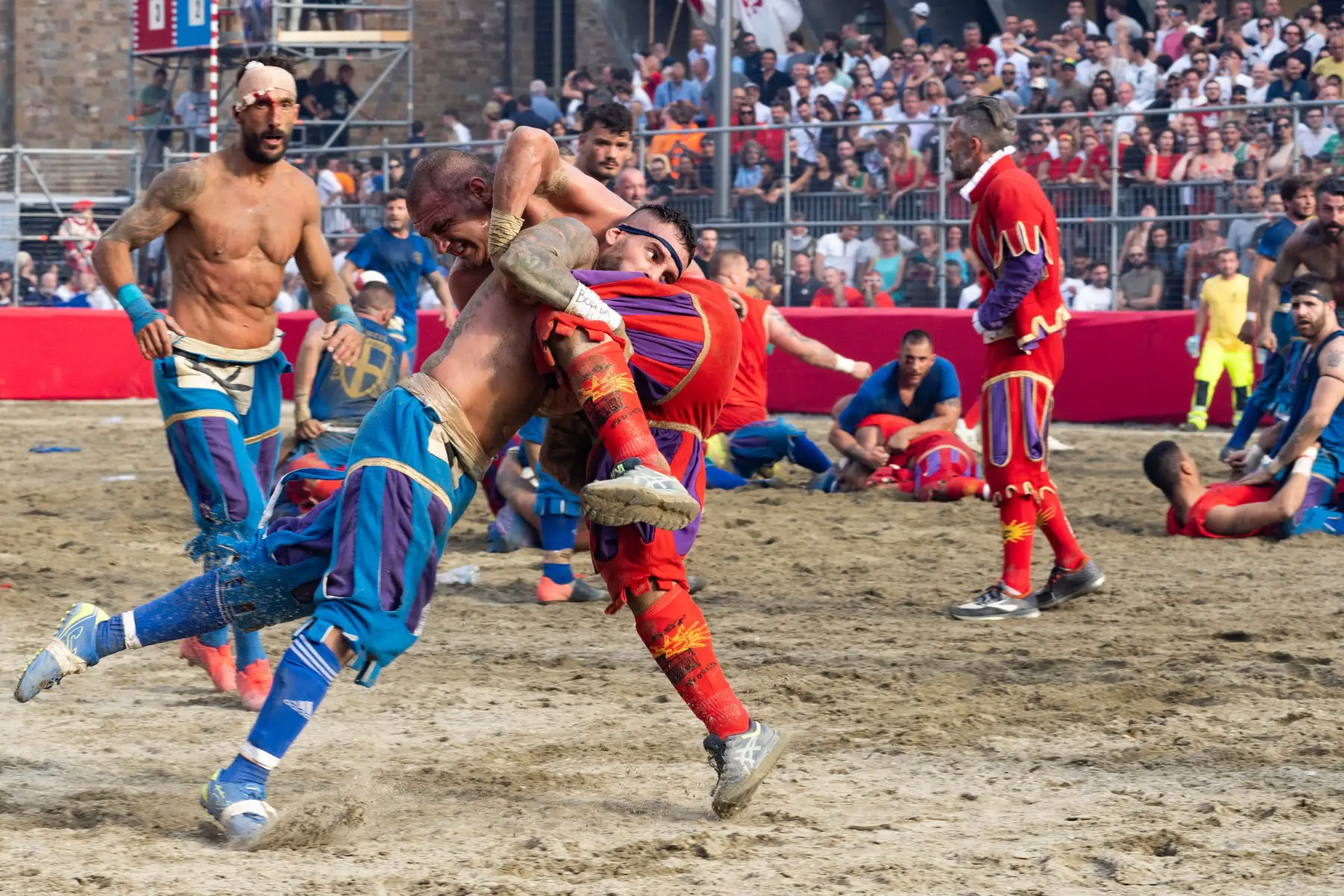Two opposing teams wrestling during the Calcio Storico in Florence