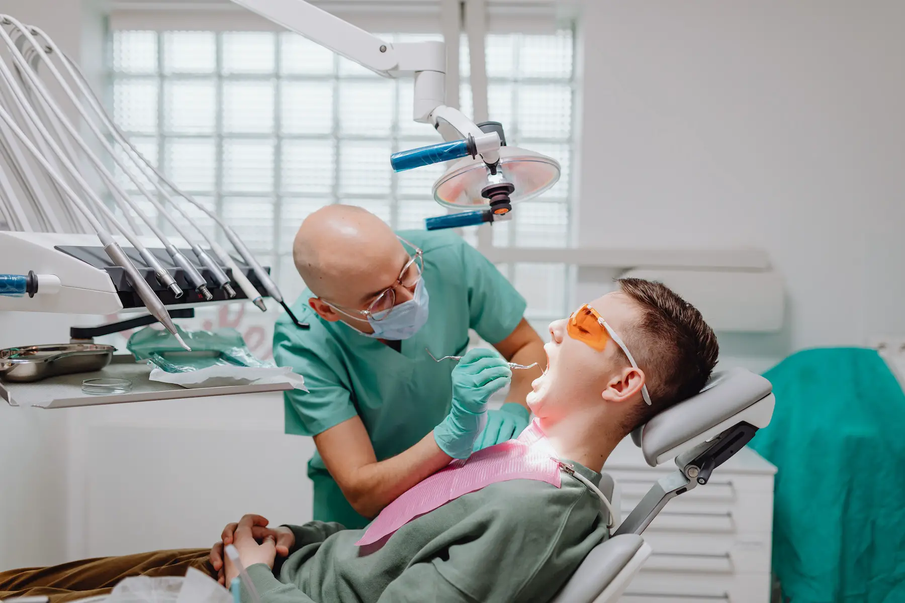 Dentist inspecting mouth of patient in the exam chair