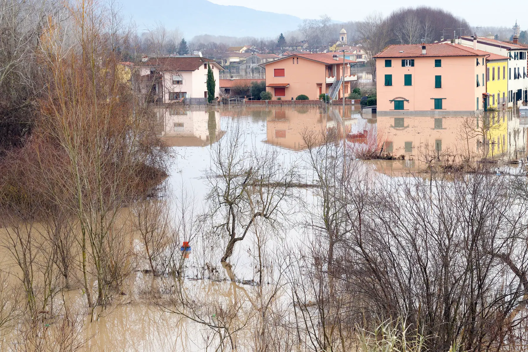 A large area of flooded land with buildings in the background that have water up to the windows
