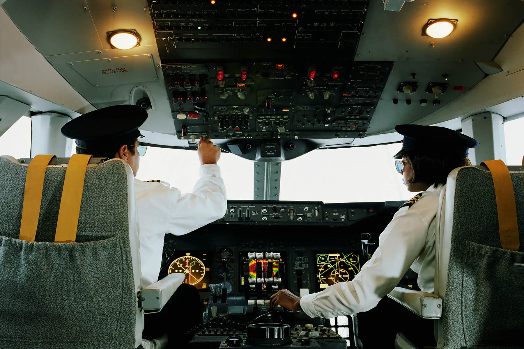 Pilots - one male, one female - in the cockpit of an airliner