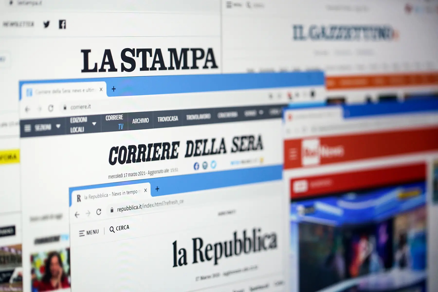 A screen showing online home pages of Italian newspapers La Stampa, Corriere della Serra, and La Repubblica