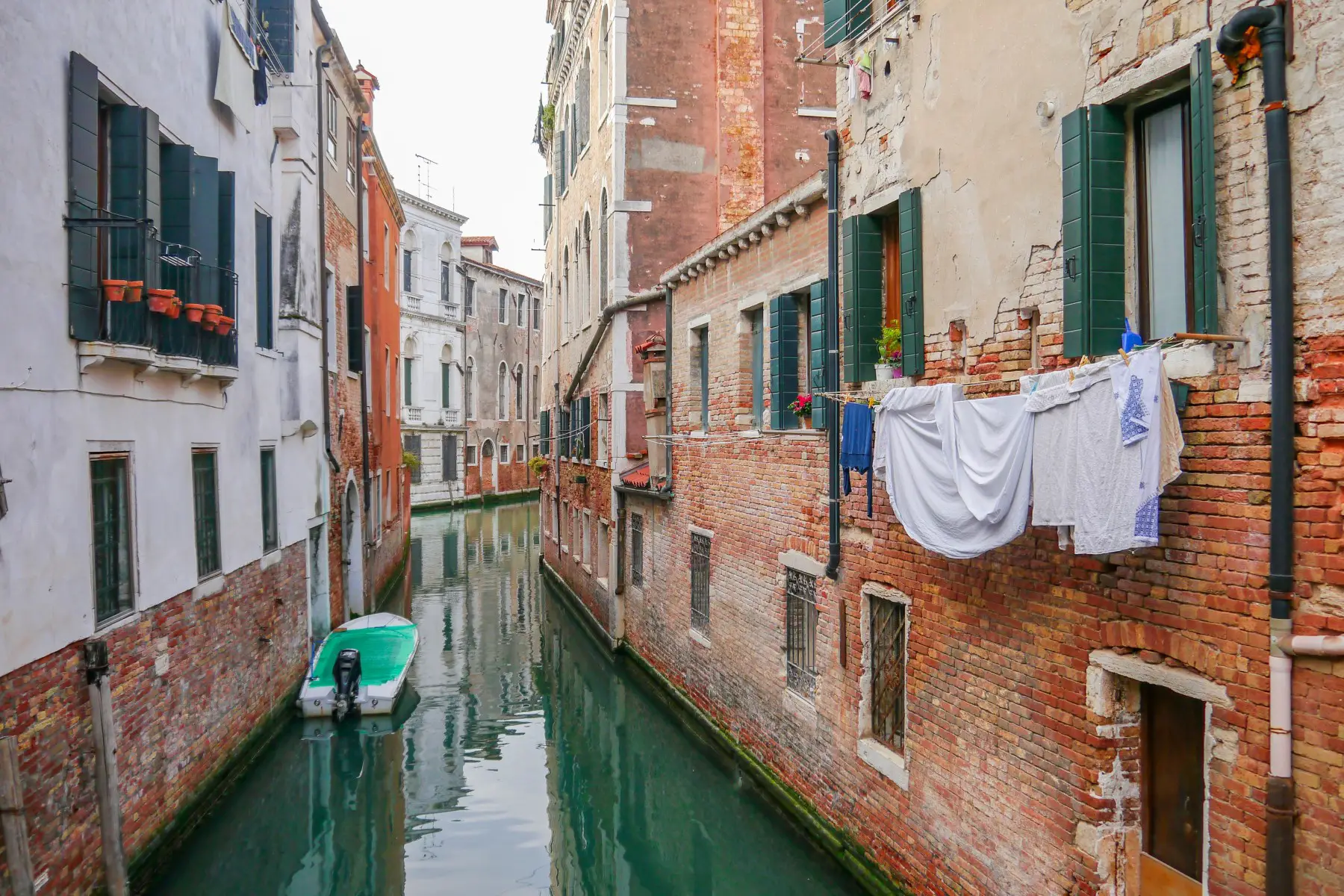 Laundry hanging near a building, along a canal alley in Venice, Italy.