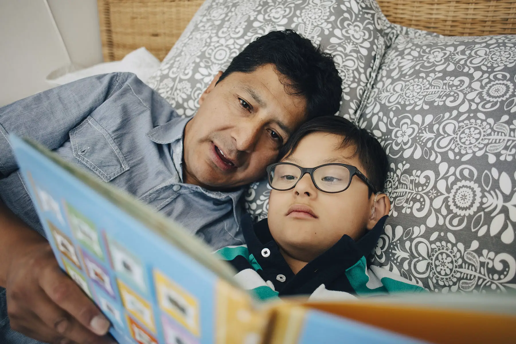 Father reading his son a bed time story.