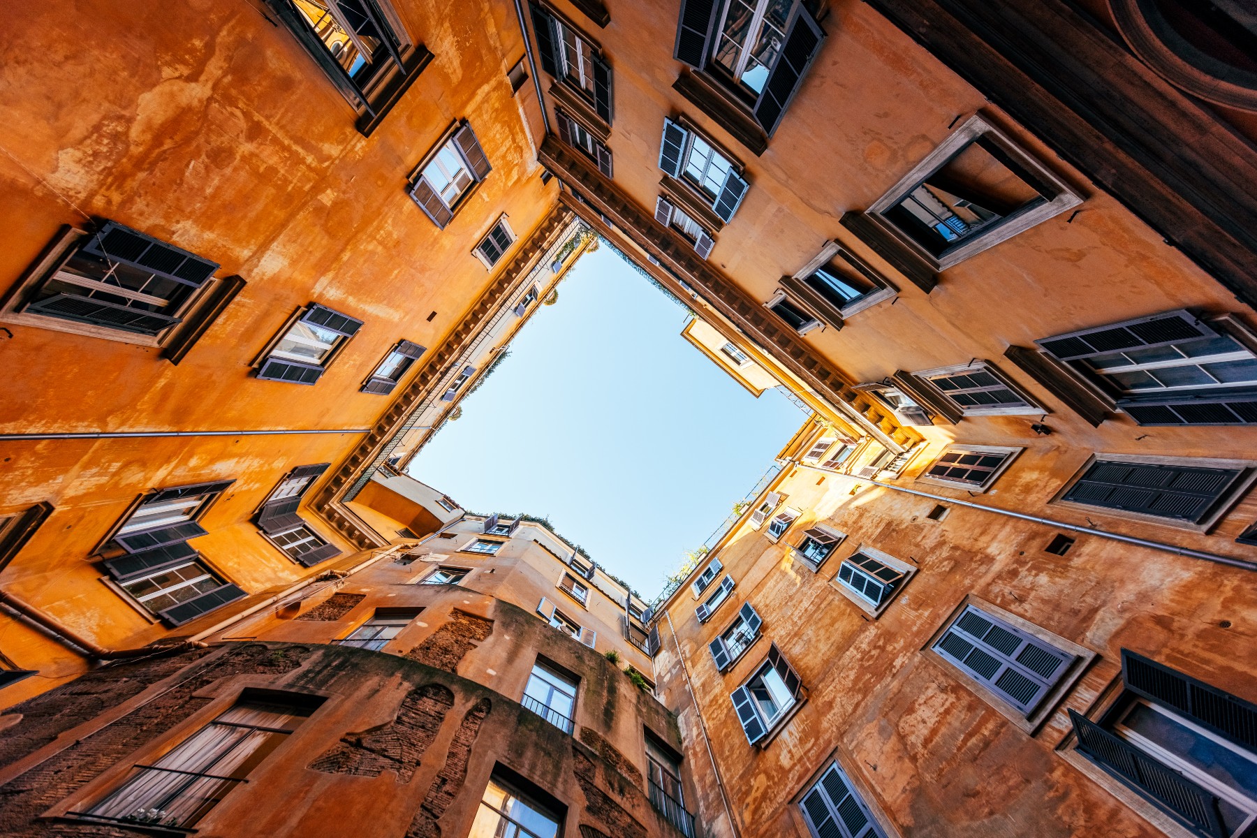 Low wide angle view of residential apartments house inner court yard in Rome, Italy.
