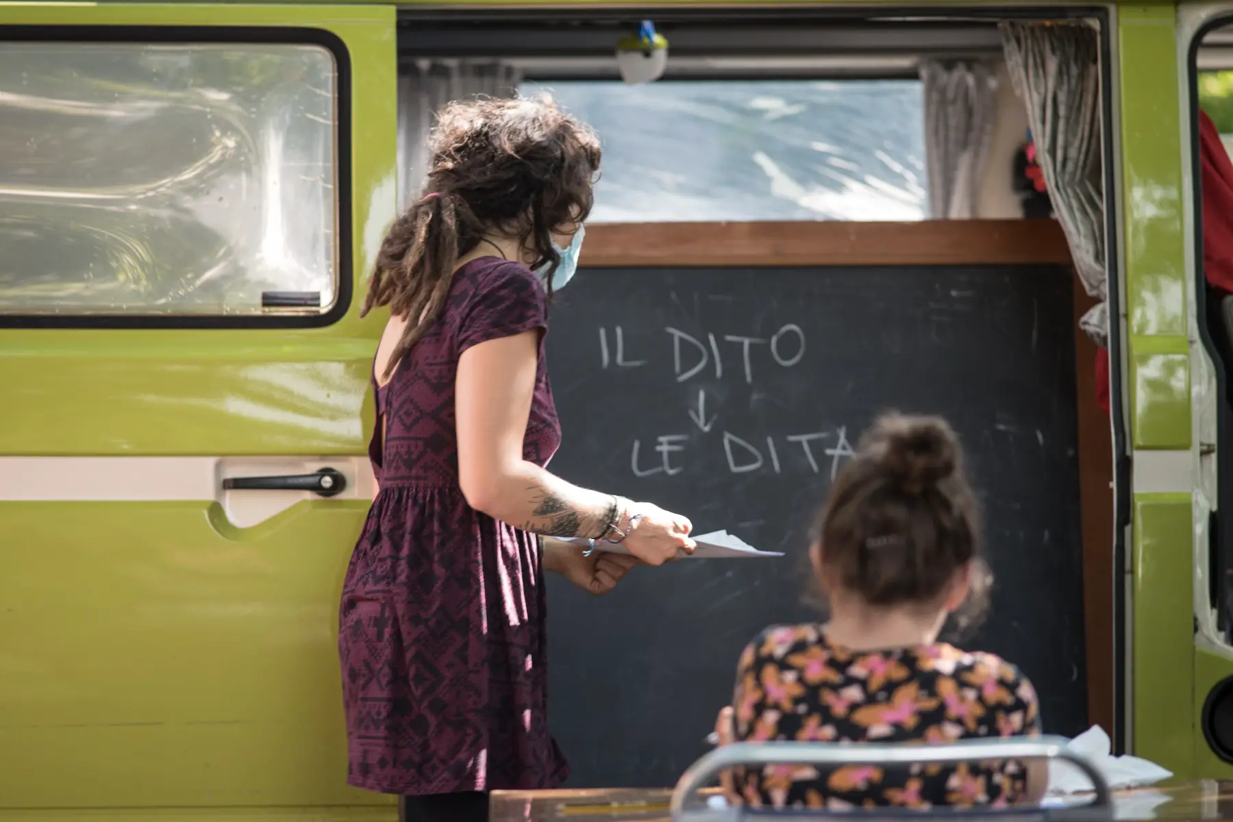 Woman teaching a child Italian from the back of a van.