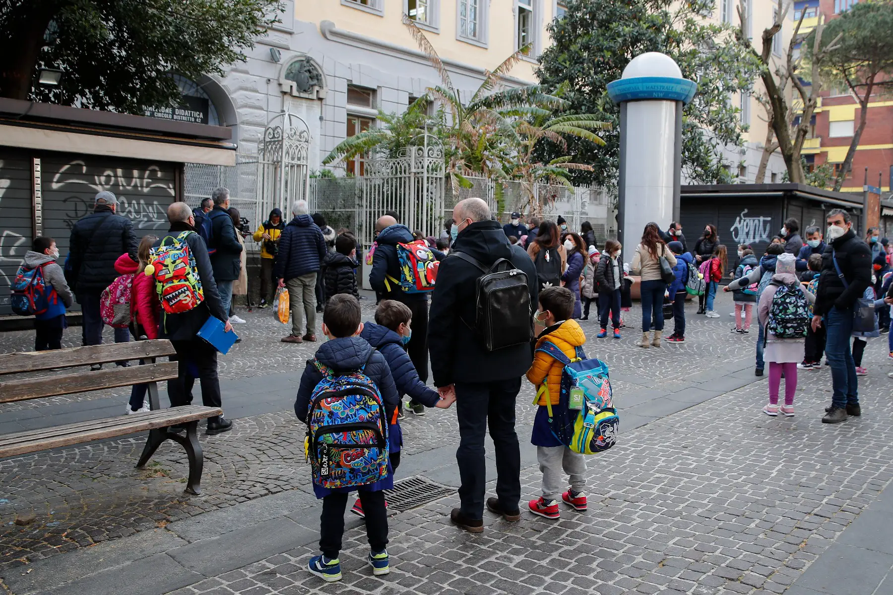 Pupils and parents wearing protective masks next to the entrance of an primary school in Naples, Italy.