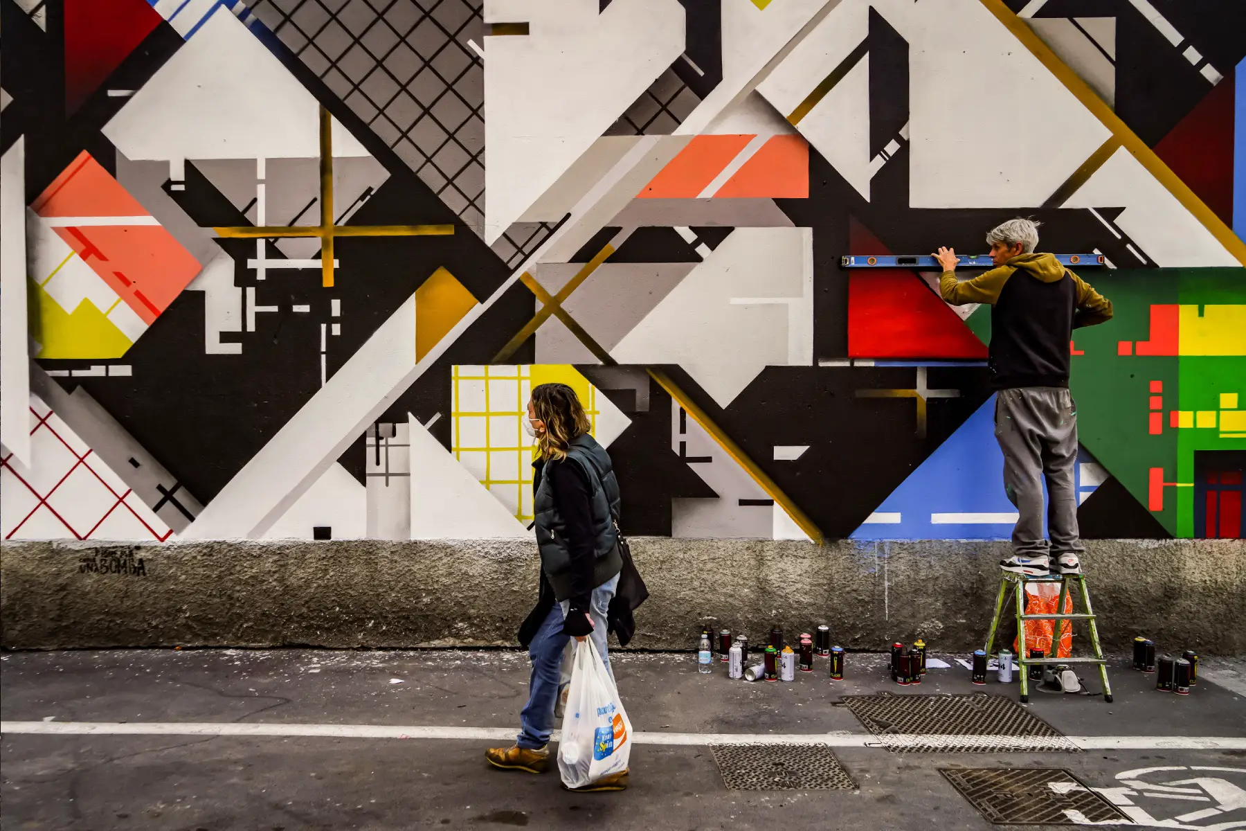 Women walks past a street artist in Milan