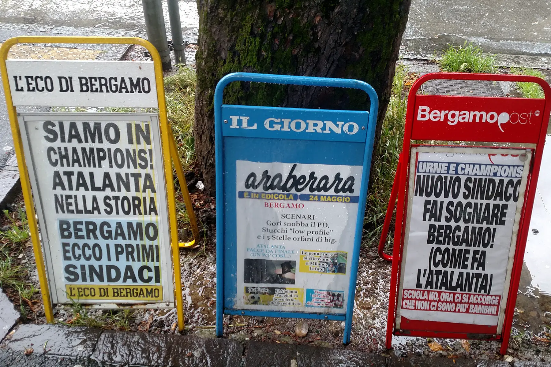 Local news headlines on boards in Bergamo