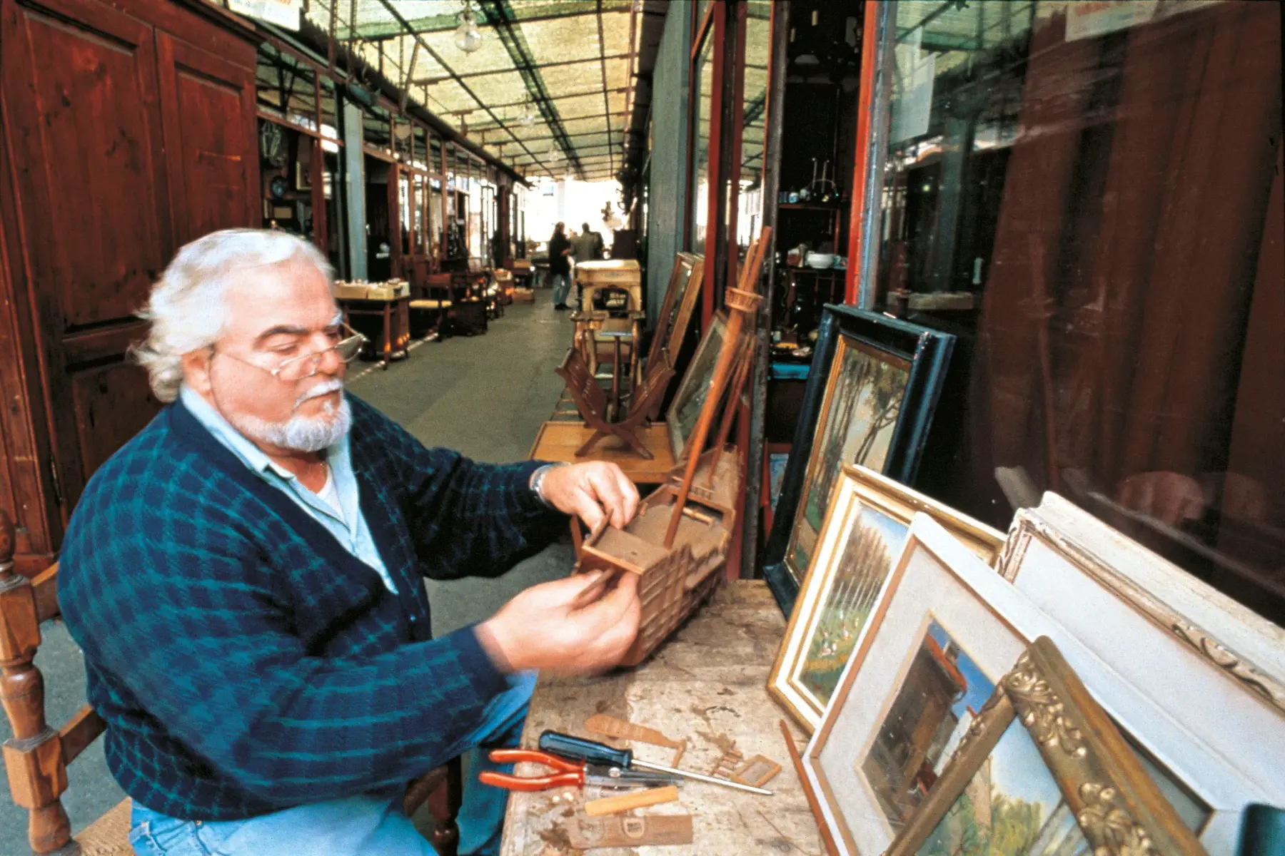 Artisan building a model of wooden ship at his stall in the flea market (Piazza dei Ciompi)