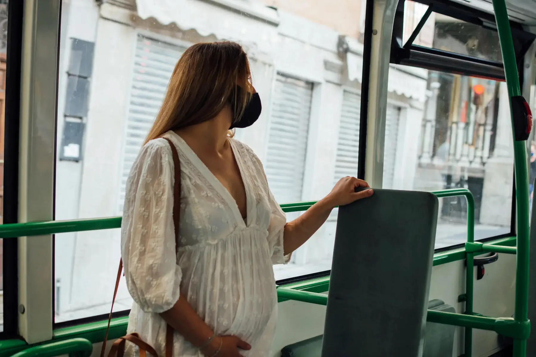Pregnant woman taking a bus in an Italian city