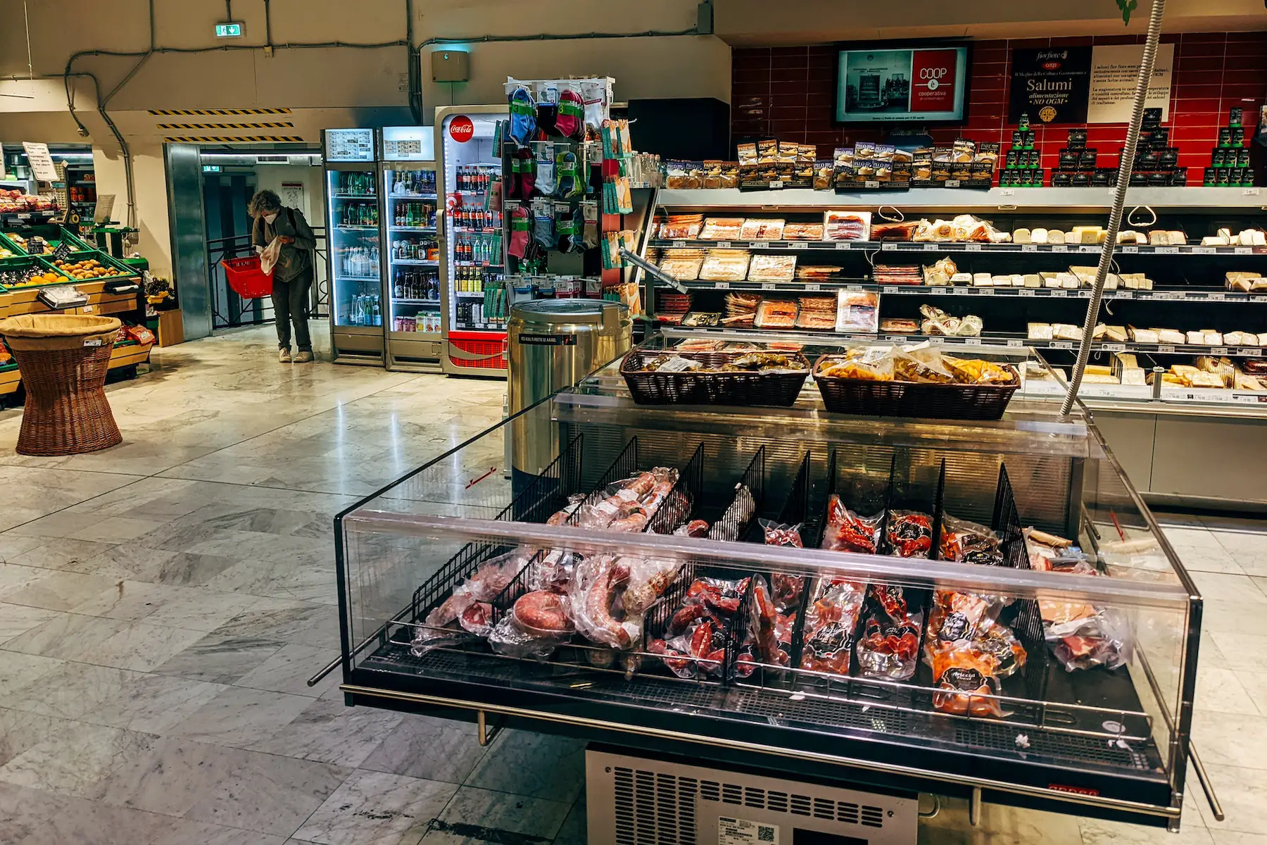 Cheese, meat, and produce are displayed in an Italian grocery store