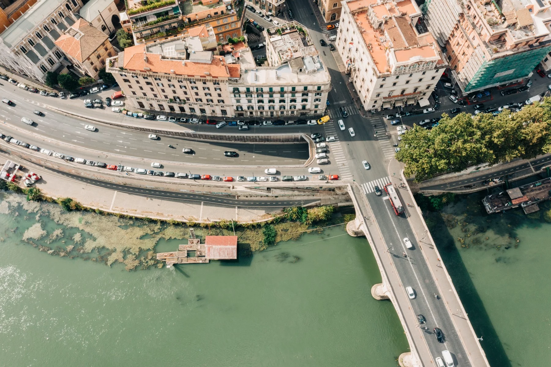 Aerial view of a road near the waterfront in Rome, Italy. Cars are parked along the way.