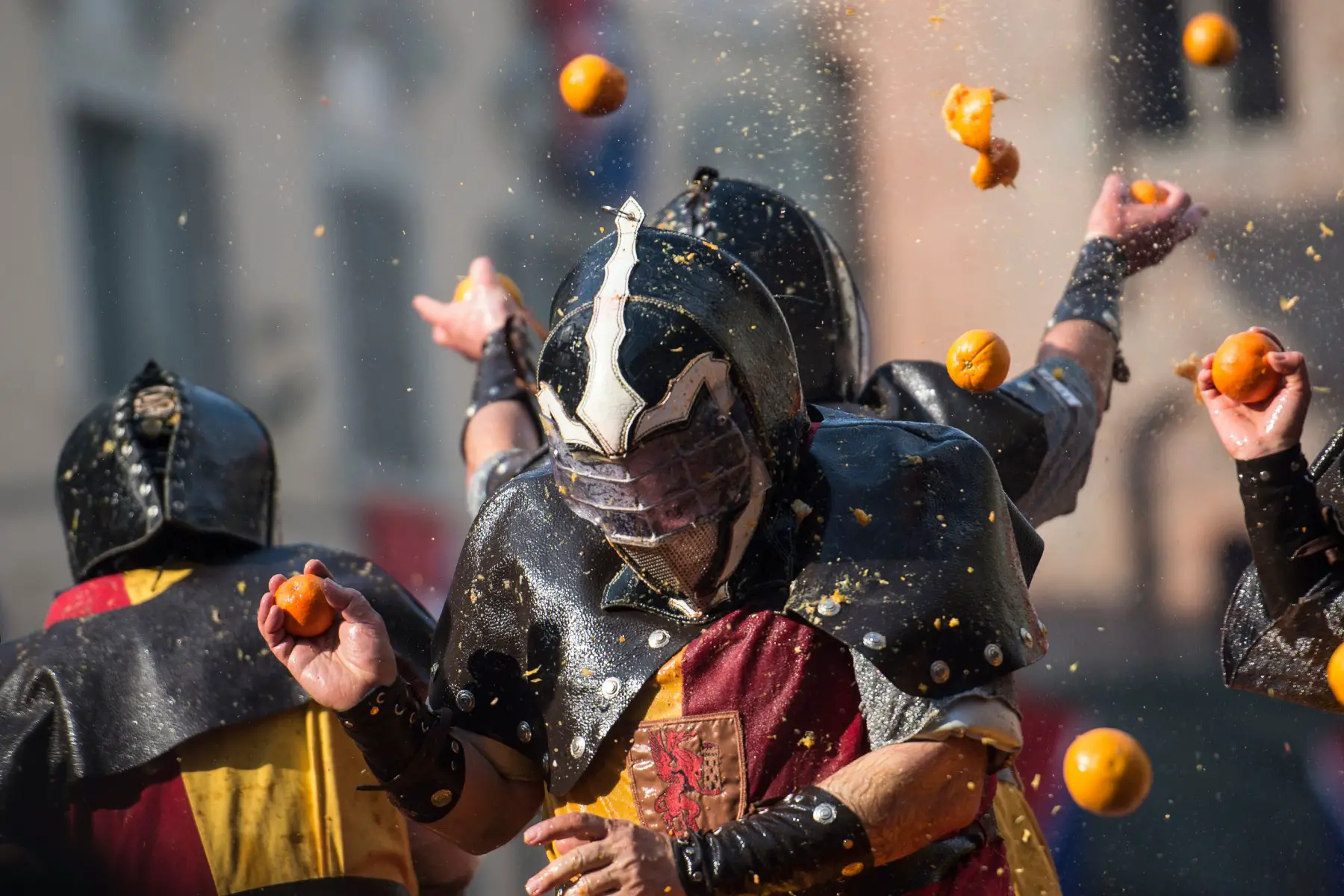 Crowd throwing oranges during the battle of oranges at the Storico Carnevale di Ivrea
