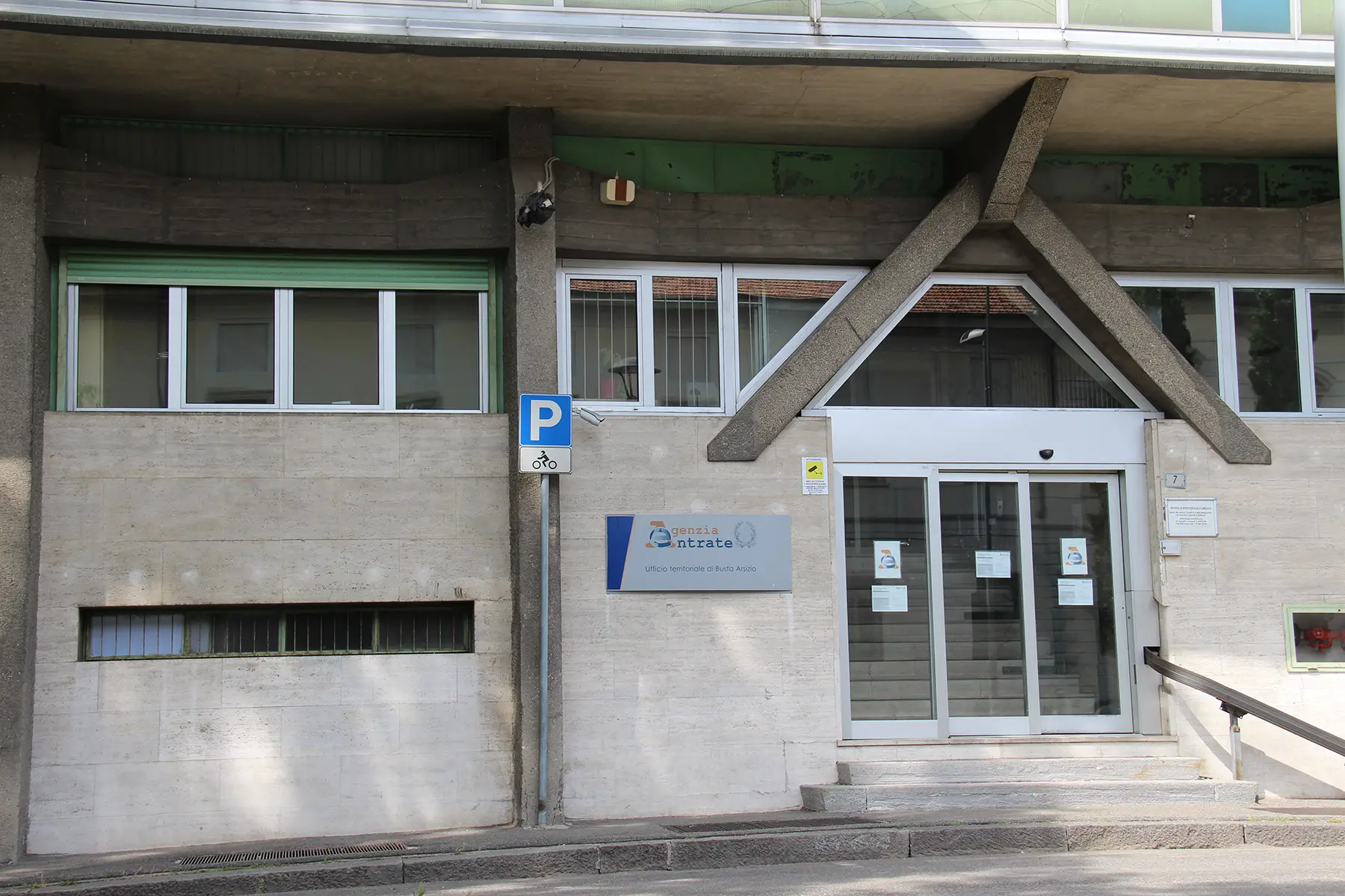 Revenue Agency Office in Busto Arsizio, Varese, an ugly concrete office building. A sign outside says Agenzia entrate.