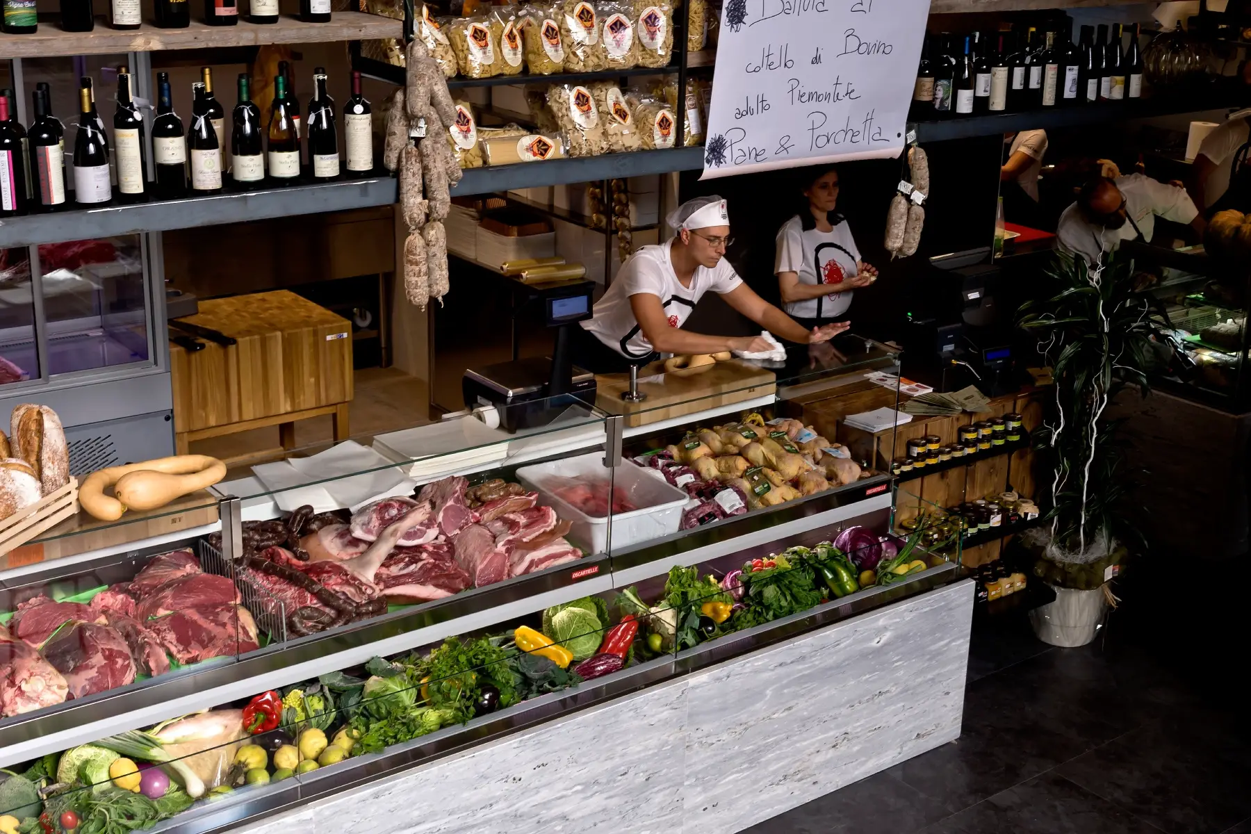 Vendor sells organic meat, fresh produce, and wine at Mercato Centrale Roma