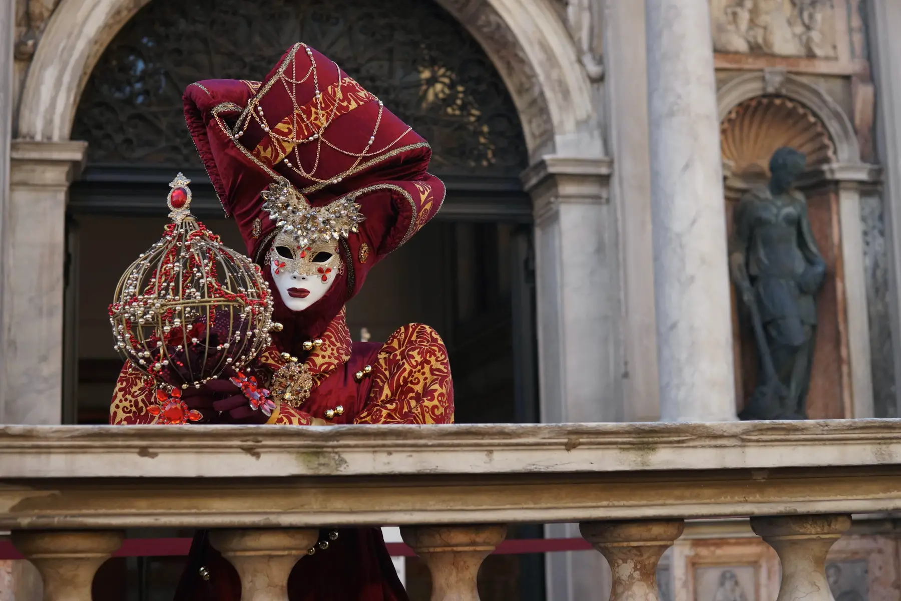Woman in a magnificent, red costume and mask for the Venice Carnival