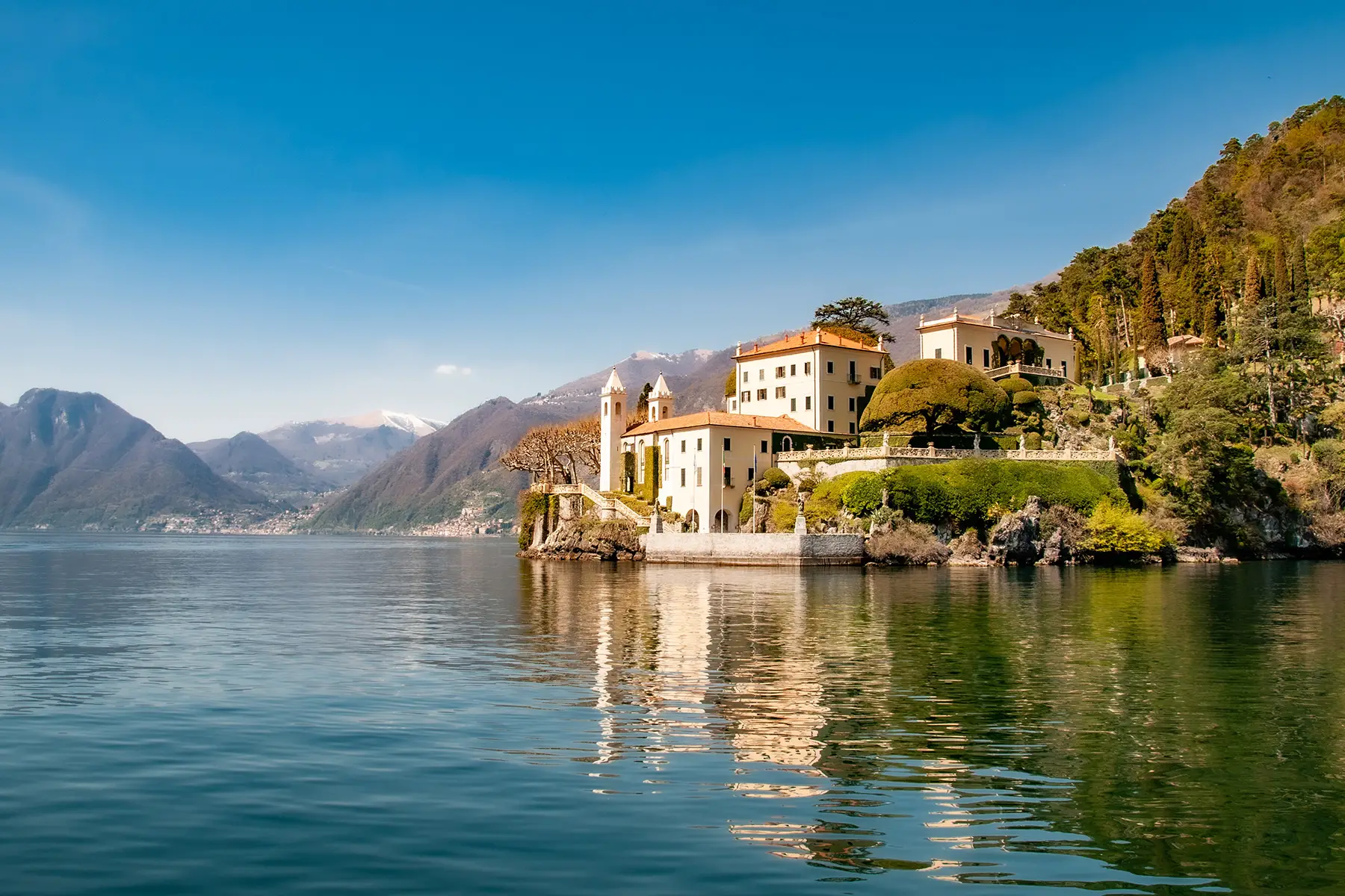 A view of Lake Como on a beautiful sunny day, house in the distance.