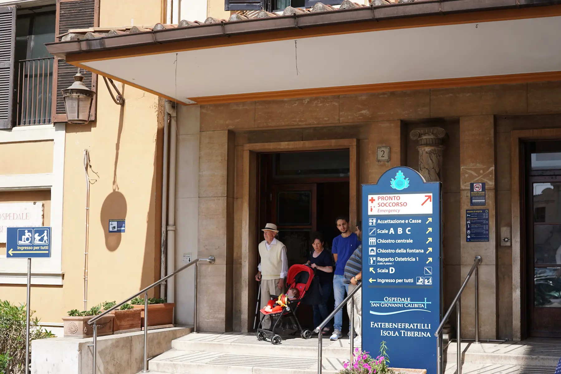 A family walks out the doors of Ospedale San Giovanni Calibita in Rome, Italy