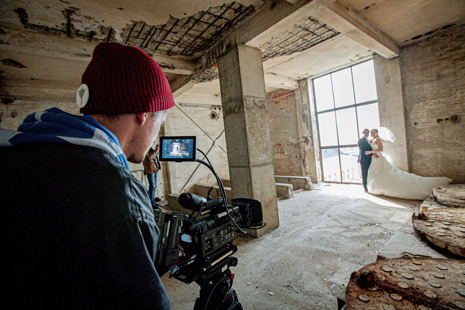 A videographer and photographer doing a wedding shoot in an old building
