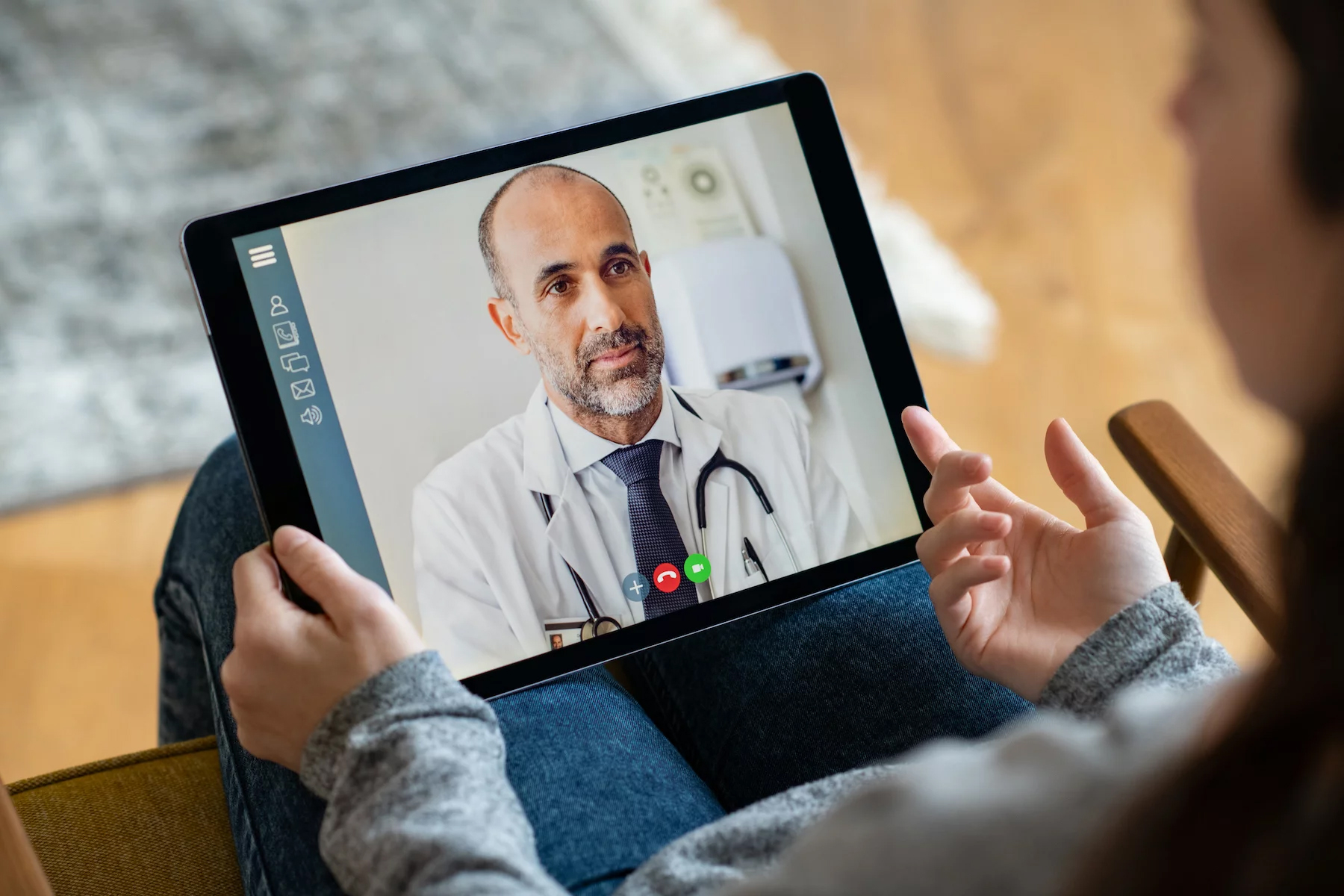 Woman on a video call with her doctor from home via tablet