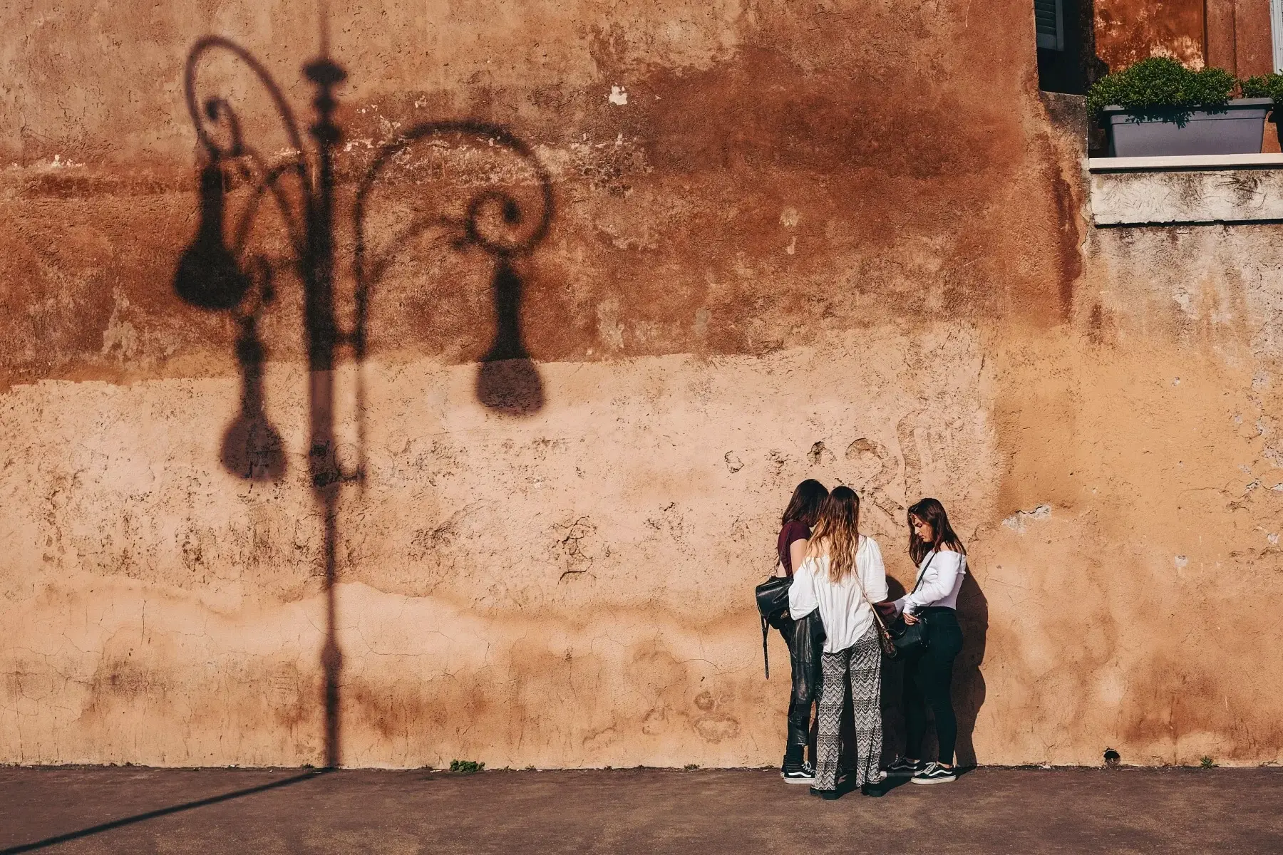 Three young women chatting on a street in Rome