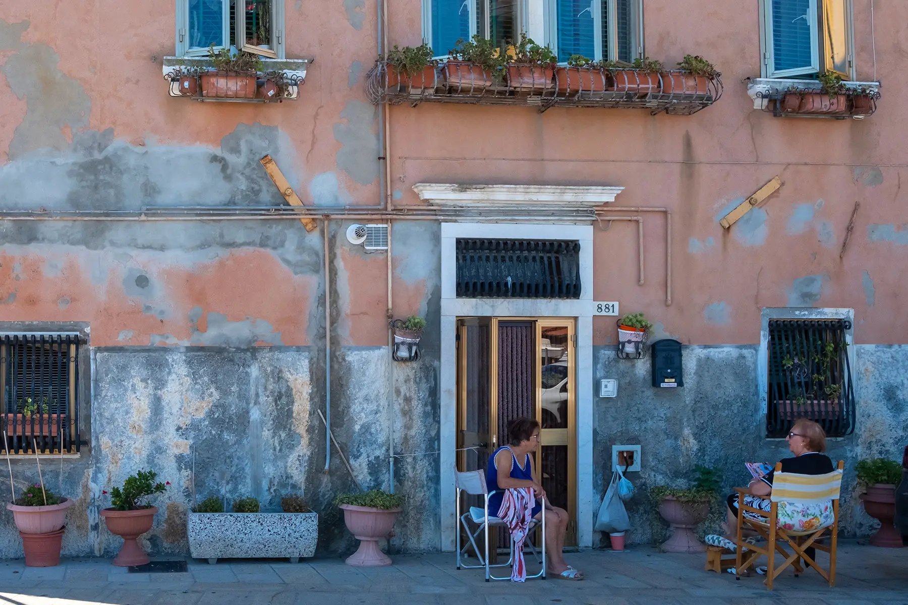 Women sitting outside an old house in the summer