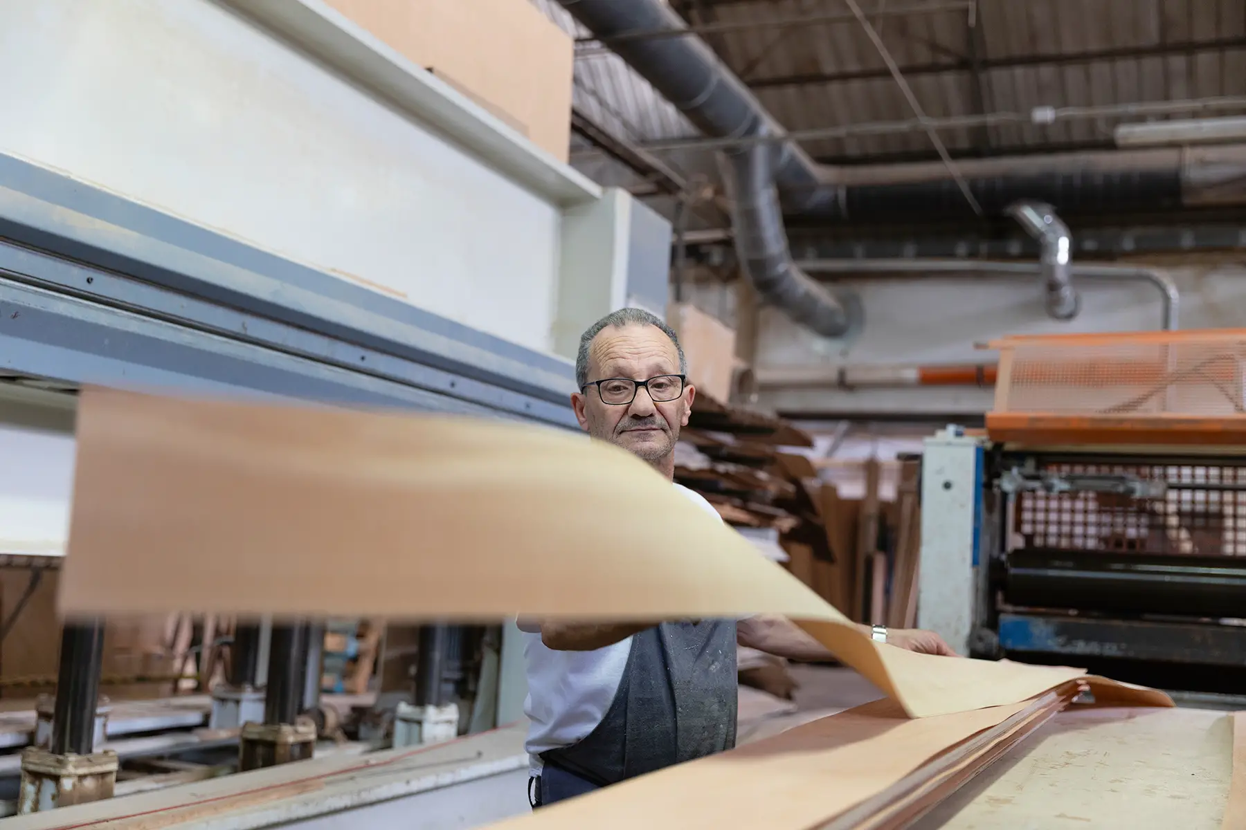 A senior man working with a wood laminate sheet