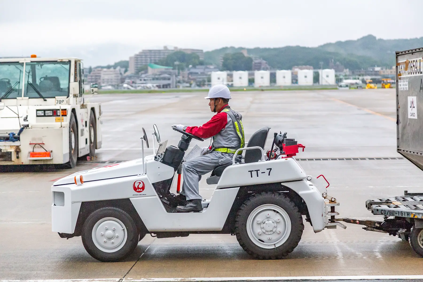 A baggage handler driving a baggage truck at Fukuoka airport in Japan
