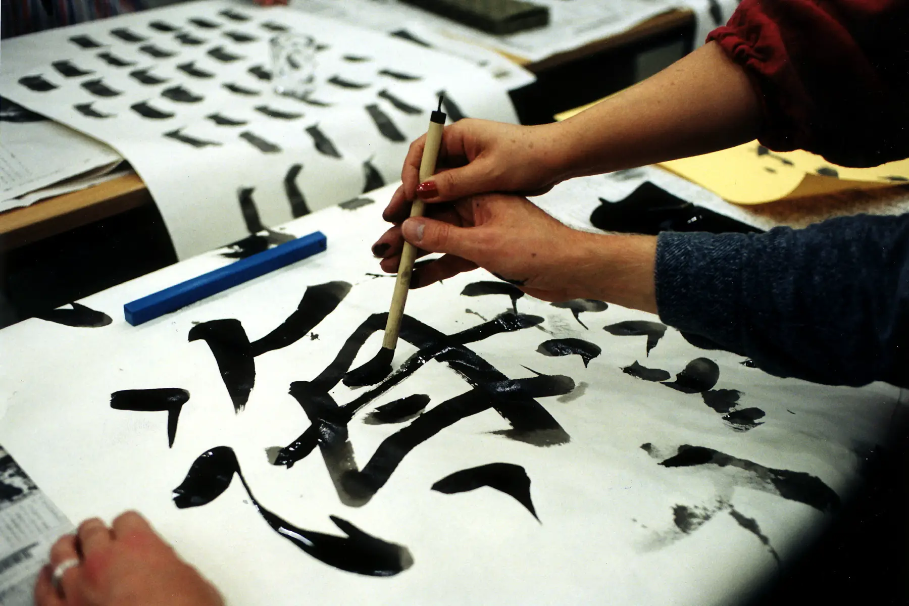 Two hands drawing Japanese calligraphy