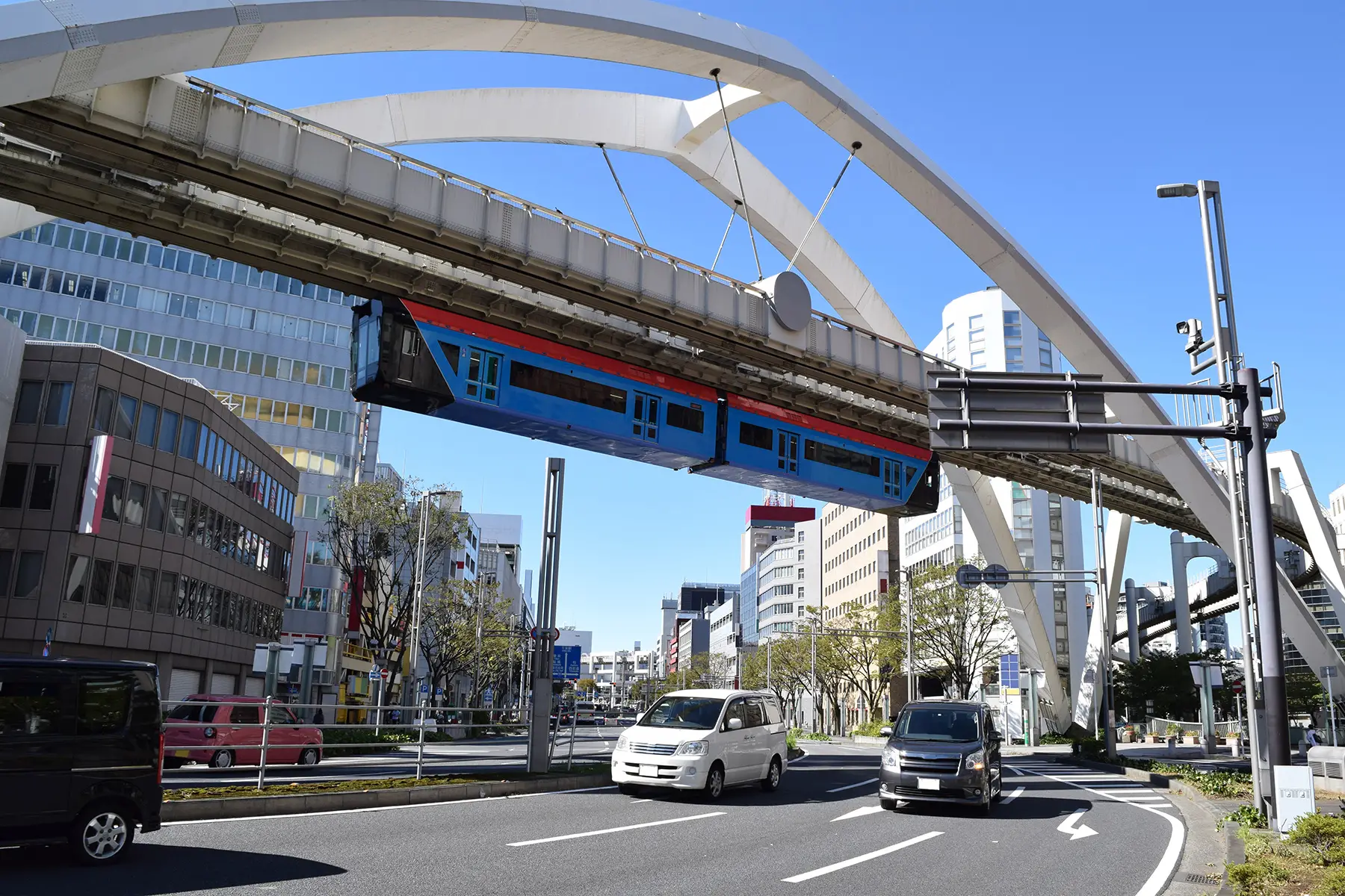 A monorail going above a road in Chiba, Japan.