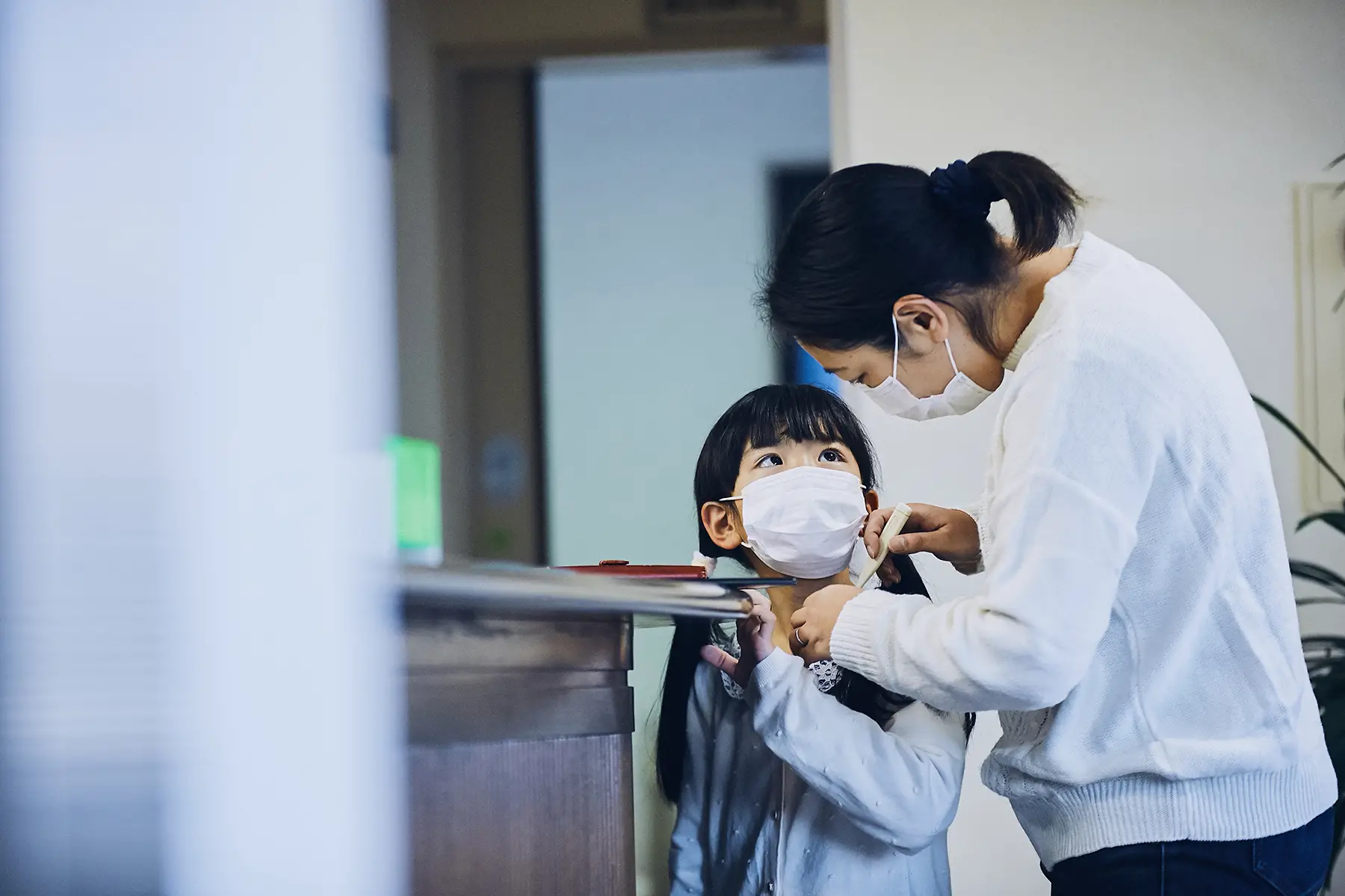 A child and her parent at the hospital reception
